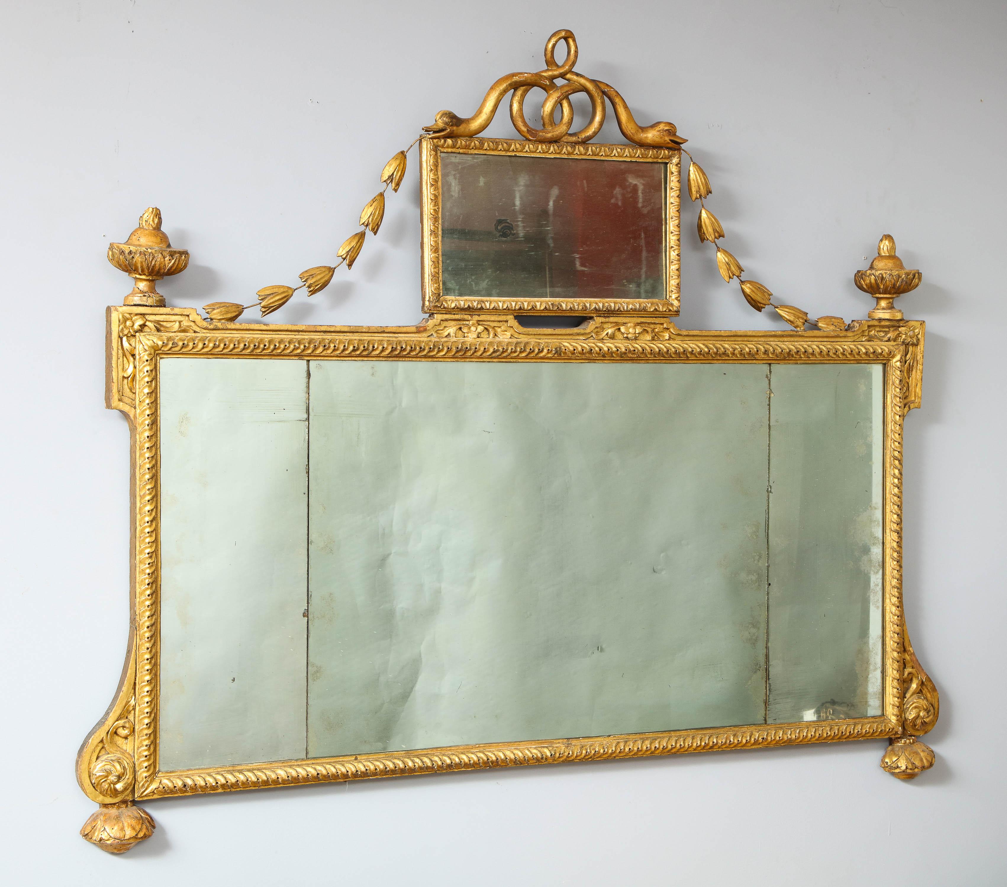 Fine 18th century Italian giltwood overmantle mirror, the crest with entwined serpents over center mirrored tablet with bell flower swags draping to urn finials, the triple mercury plate center with guilloche carved frame, scroll and foliate carved