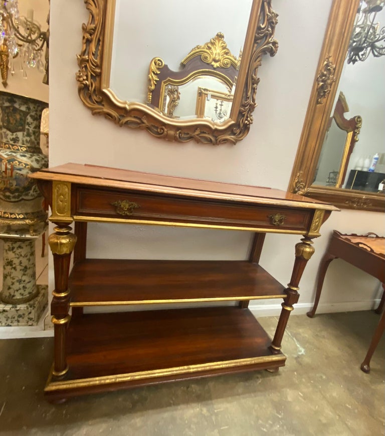 Italian Neoclassical console table/ server, 19th c., rectangular top with parcel gilt molded edge, single frieze drawer, turned and fluted vertical supports, two tiers of open shelves, rising on bun feet, wear and loss to finish, later trim board