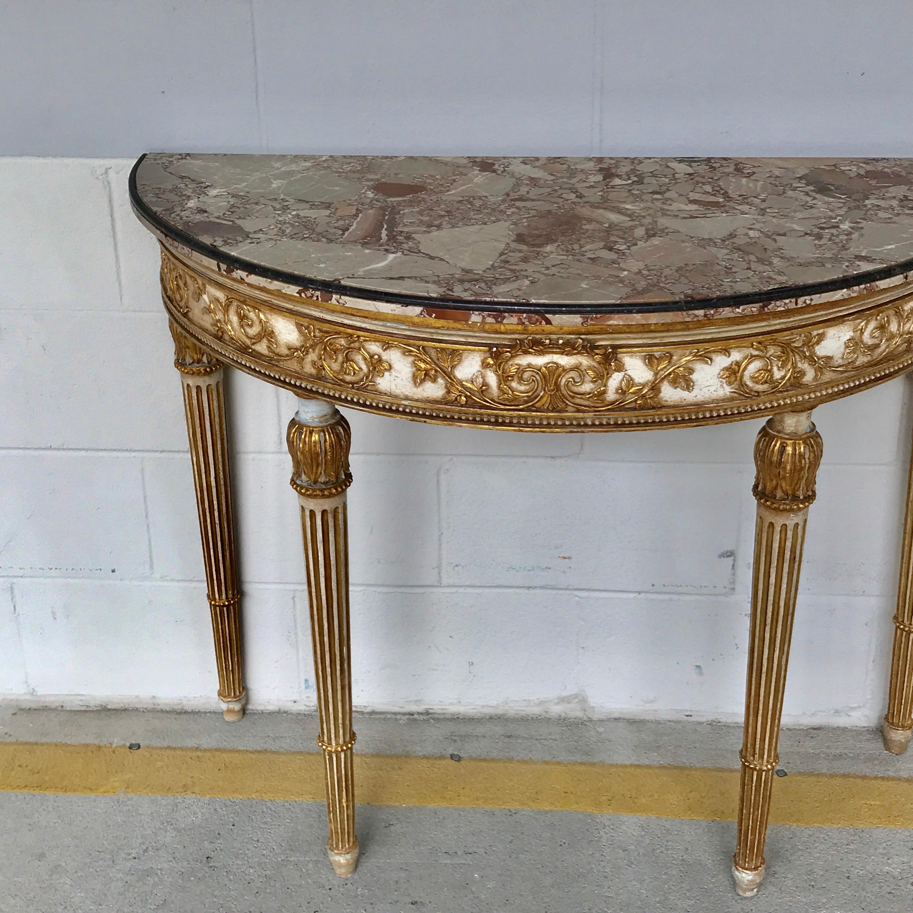 Italian neoclassical giltwood marble-top console, of demilune form with beautiful specimen marble top with inlaid black marble edge, raised on a conforming carved parcel gilt base with reeded legs.