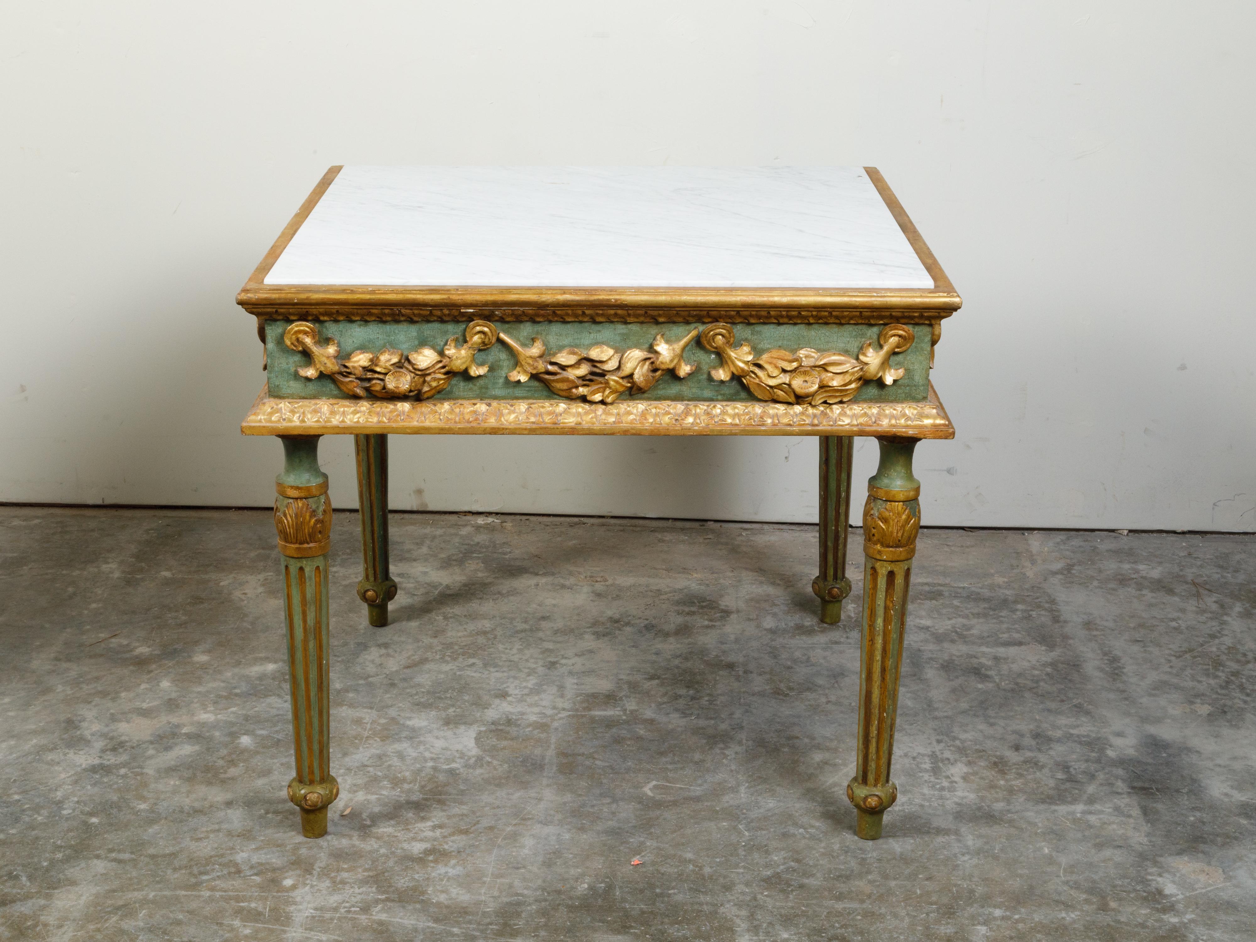 An Italian Neoclassical period painted and parcel-gilt center table from the 18th century, with white marble top and carved garlands. Created in Italy during the 18th century, this center table features a square white marble top sitting above a