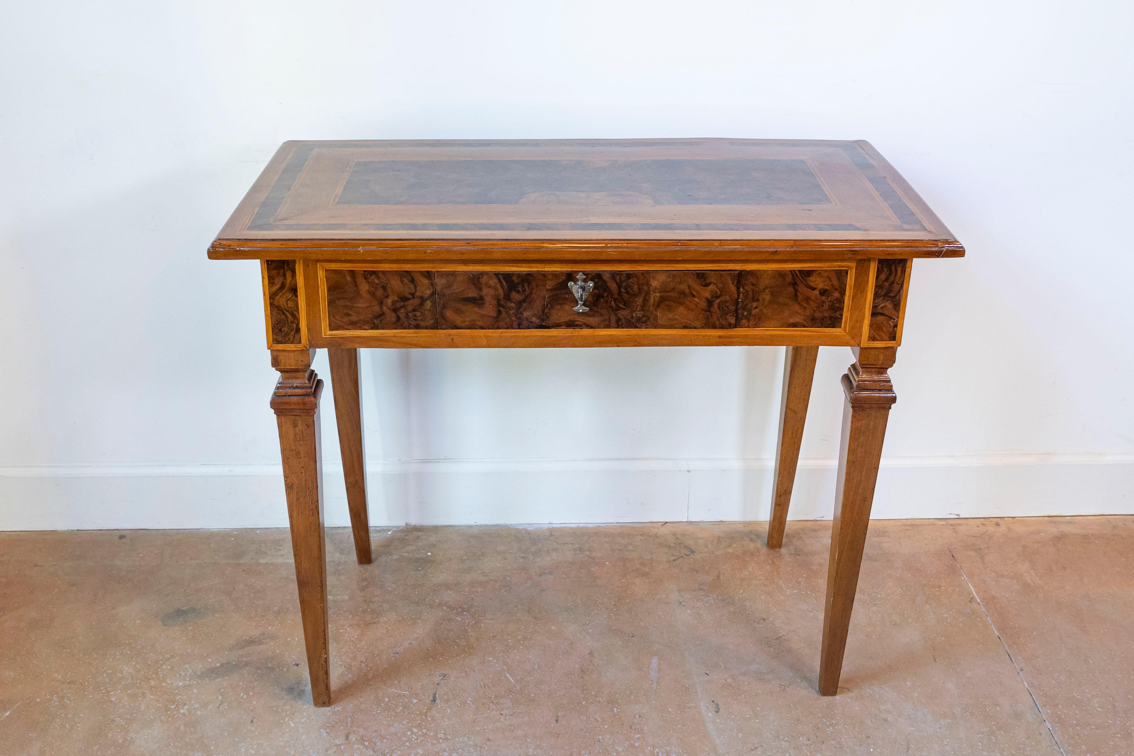 Consolle di epoca neoclassica in mogano e noce del XVIII secolo con decorazioni a intarsio, gambe affusolate e cassetto singolo. Creata in Italia nel XVIII secolo, questa consolle neoclassica presenta un piano rettangolare ornato da fasce in mogano