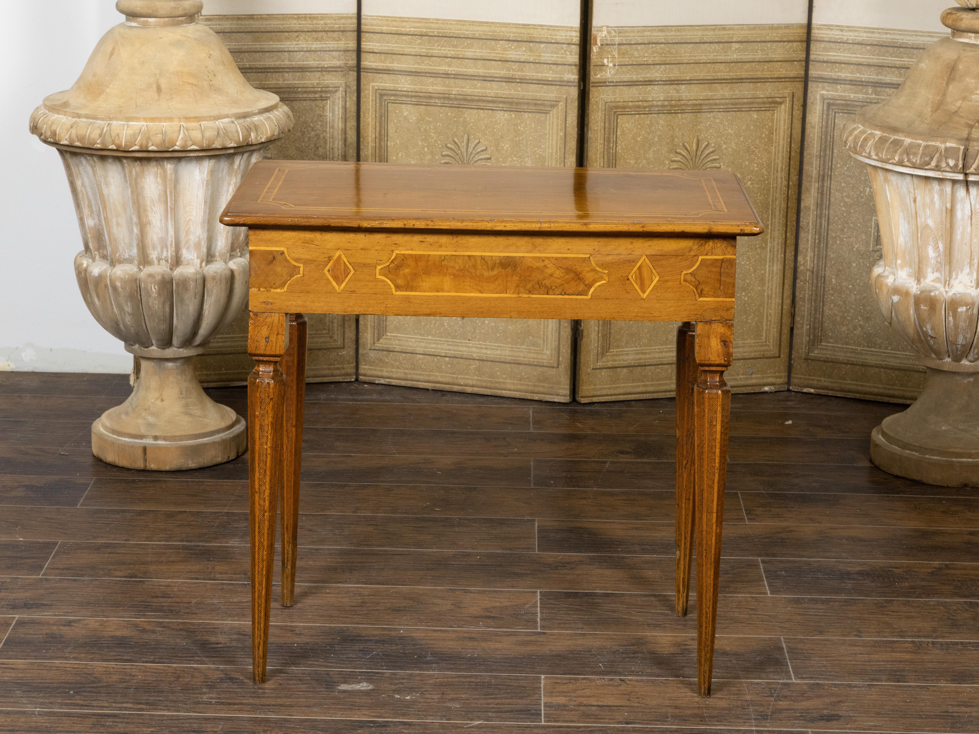 An Italian Neoclassical period walnut console table from the 18th century, with cross banding and faceted tapering legs. Created in Italy during the 18th century, this Neoclassical walnut console table features a slightly raised rectangular top with