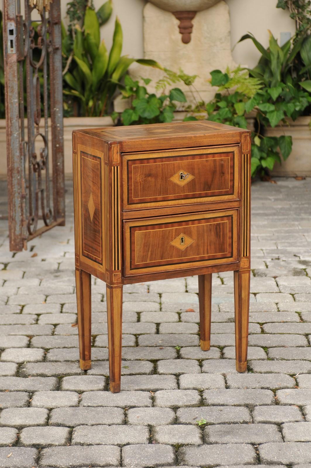 Petite Italian neoclassical period walnut commode from the late 18th century, with two drawers, delicate inlay and tapered legs. This exquisite Italian commodino features a rectangular top, adorned with a central inlaid diamond motif, surrounded by