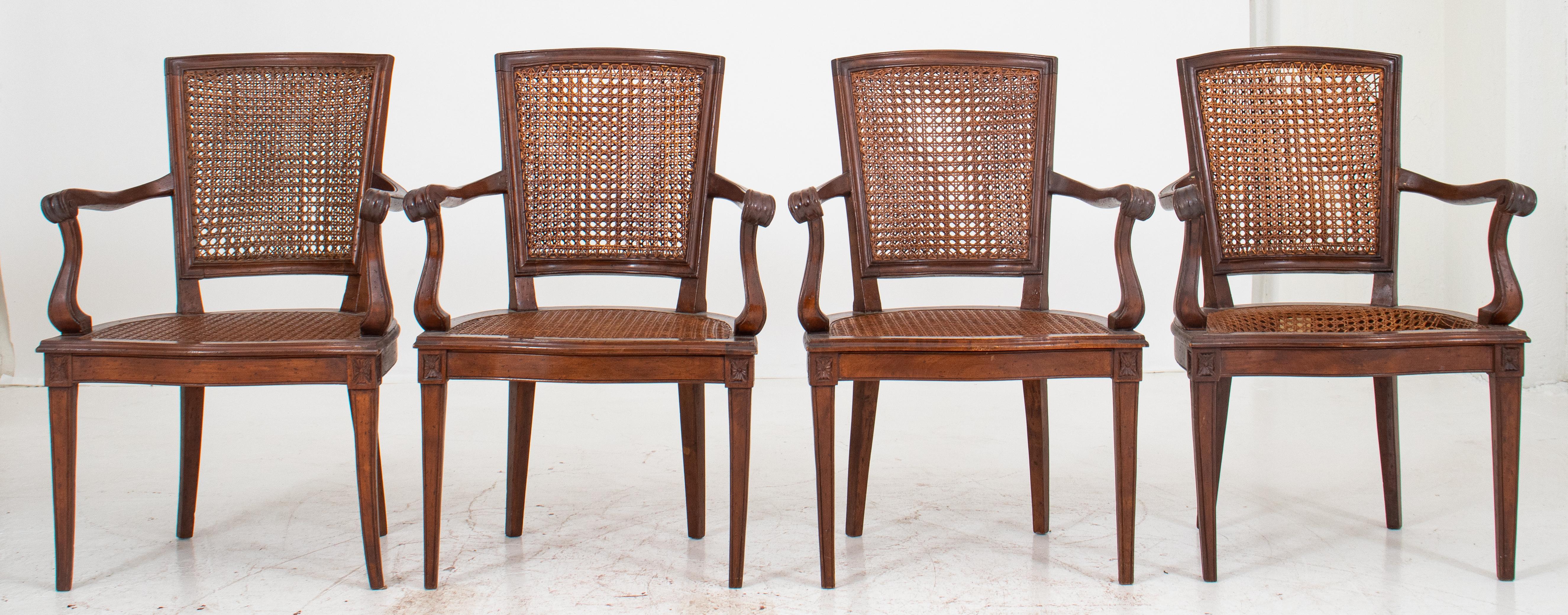 Italian neoclassical provincial style caned armchairs, each with shaped crest rail above tapering rectangular caned back with down scrolling arms above a halfmoon seat on tapering square legs. 36.5