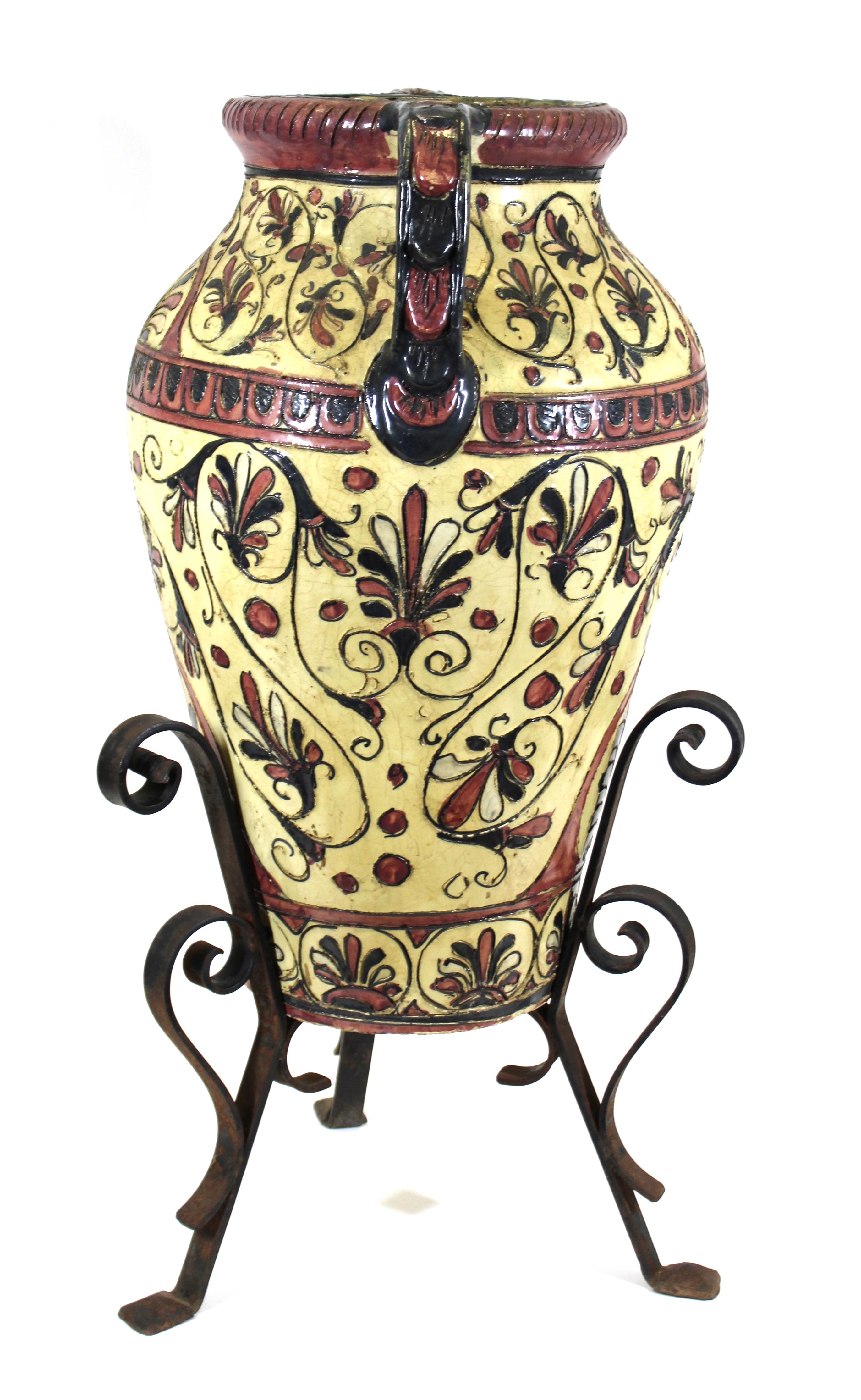 Italian neoclassical revival pottery large floor urn with ornamental sgraffito relief depicting palmettes, in pink, cream and black. The urn is placed atop its original wrought iron base. Created in Italy during the 1890s, it is marked 'made in