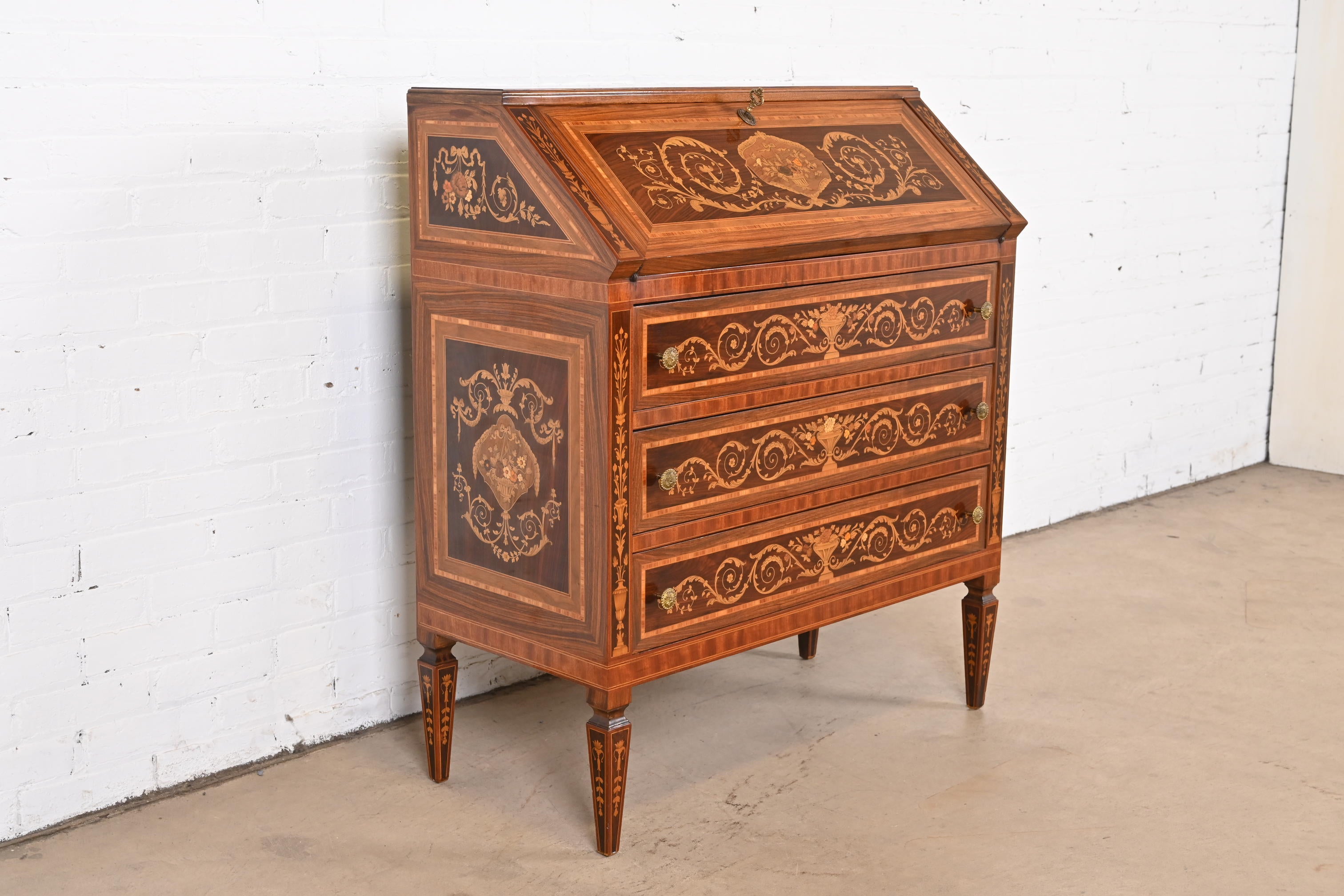 An outstanding Italian Neoclassical style slant front writing desk or secretary desk

Italy, Early 20th Century

Rosewood, with gorgeous mahogany and satinwood marquetry inlay, and original brass hardware. Desk locks, and key is