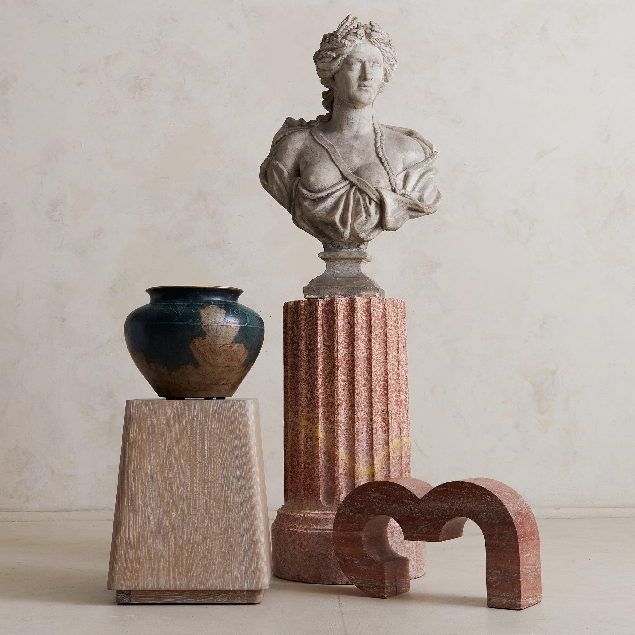 A fluted pedestal in deep rose veining, this sculptural column is crafted from richly pigmented scagliola—a refined composite developed in 17th-century Italy as a visually opulent alternative to natural marble. The technique was especially prized