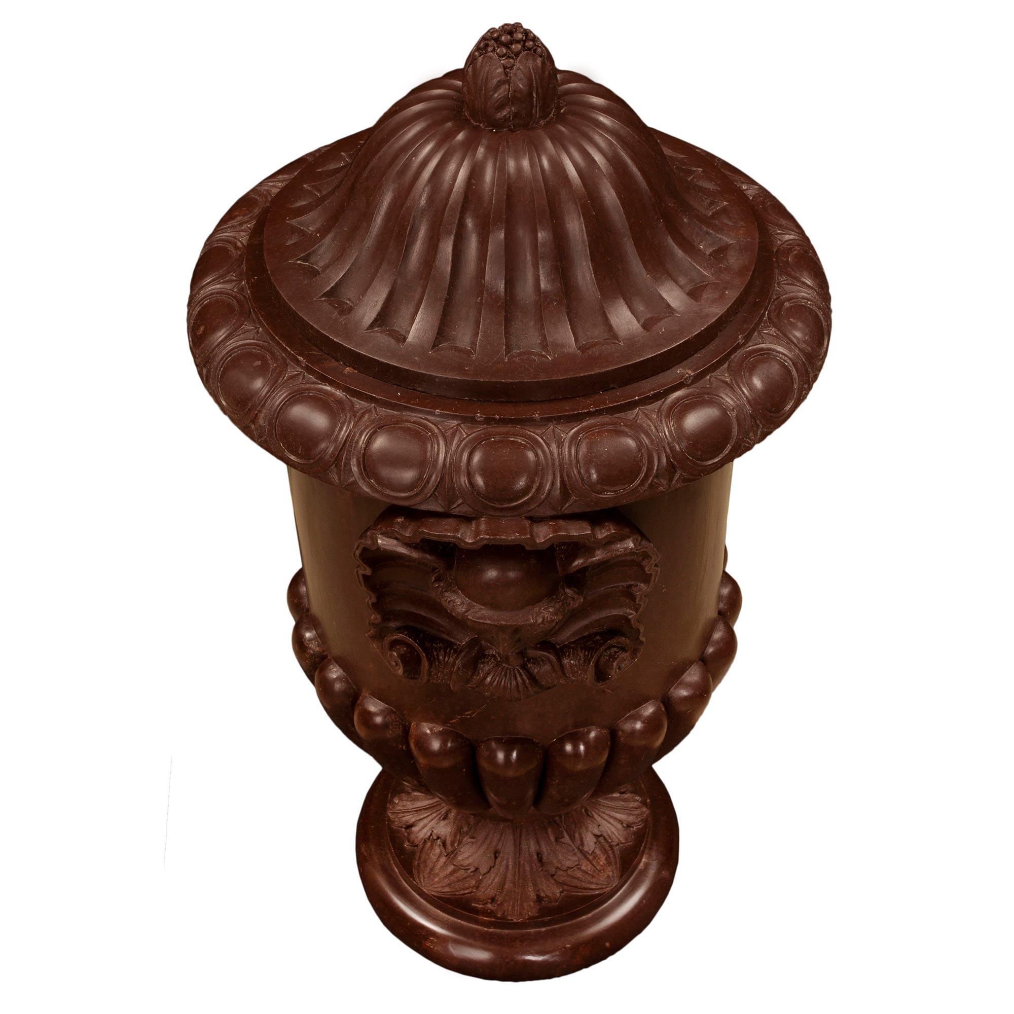 A sensational and richly carved Italian neo-classical st. mid 19th century Rosso Antico marble lidded urn. The urn is raised by a circular bullnose border with an inner design of large acanthus leaves. The bottom of the urn is decorated by godron