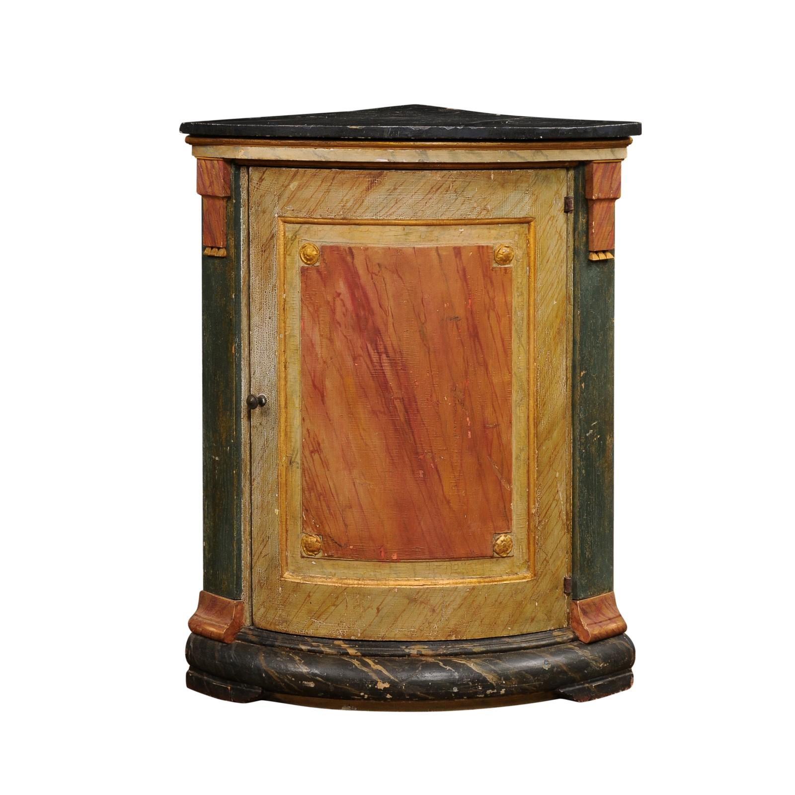 An Italian neoclassical style painted wood corner cabinet from the 19th century, with marbleized polychrome décor, single door, pilasters, gilded rosettes and rustic character. Created in Italy during the 19th century, this corner cabinet charms us