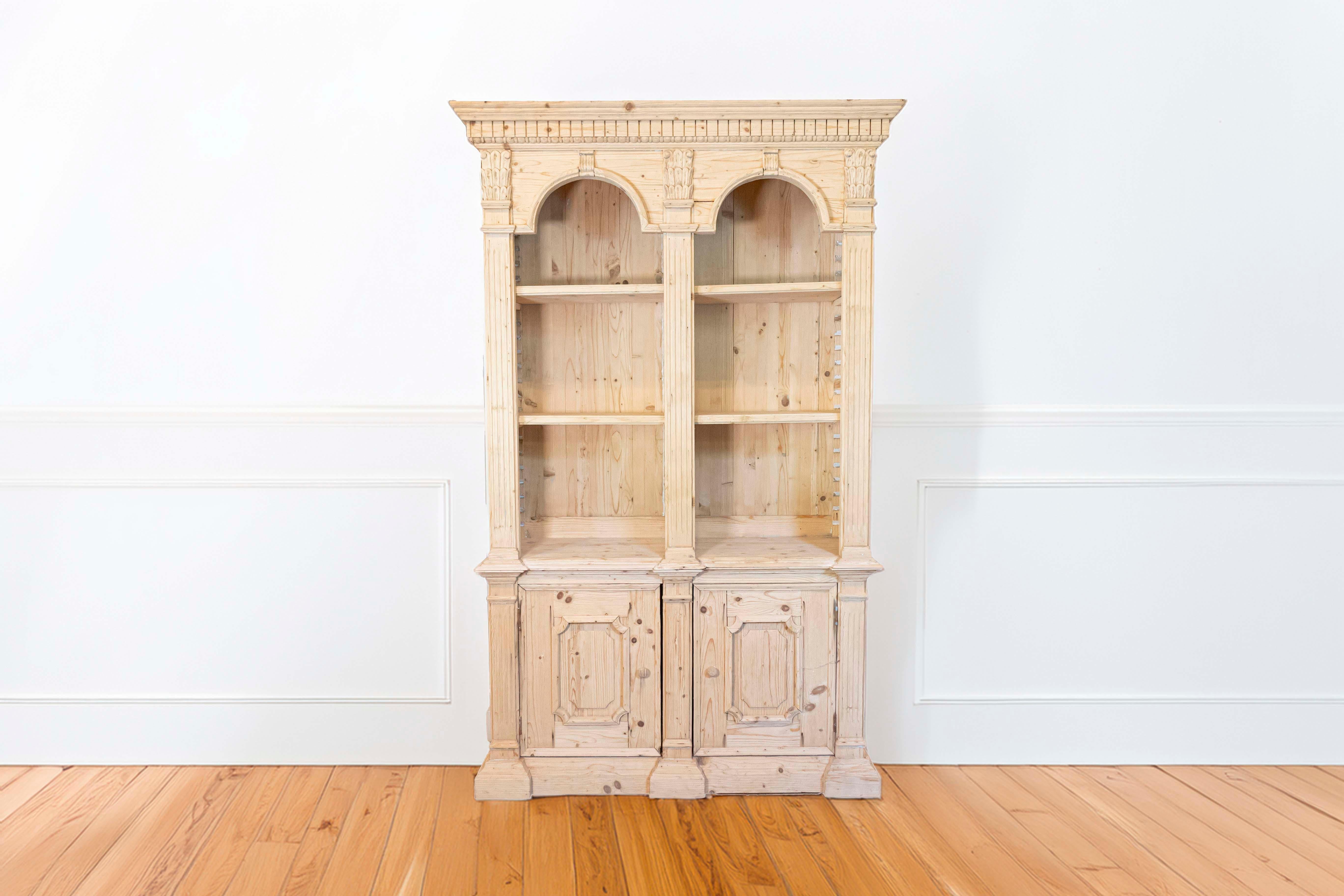 Libreria in pino in stile neoclassico dei primi del Novecento con motivi ad arco, dentelli intagliati, capitelli corinzi e dorici, lesene scanalate e ante modanate. Creata in Italia nei primi anni del XX secolo, questa libreria cattura la nostra