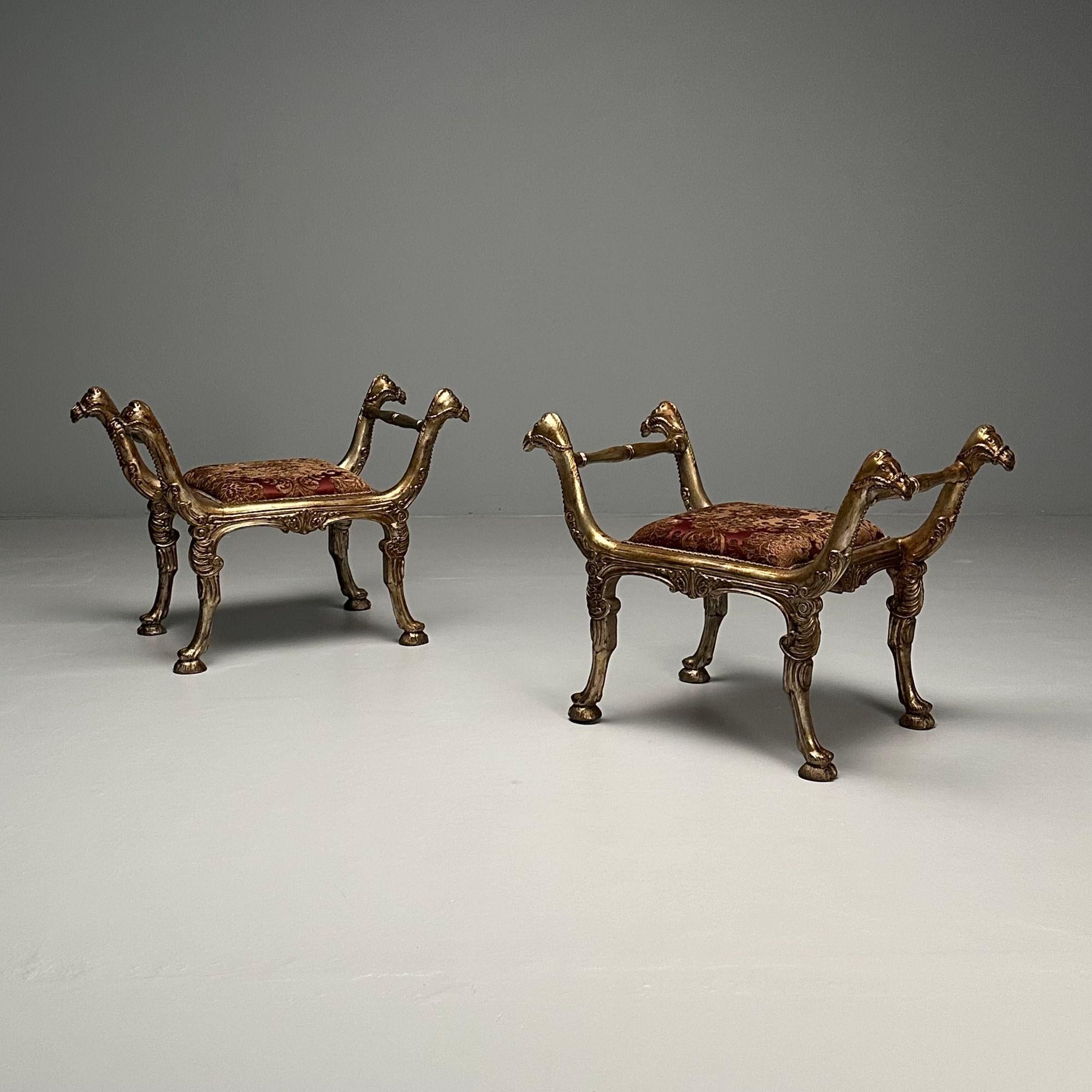 Pair of Italian Neoclassical-Style Carved and Silvered Giltwood Curule Benches

Details of note include a silvered gilt gold finish over red clay base, acanthus arms with camel head terminals, richly upholstered seats, out-swept legs and hoof feet.