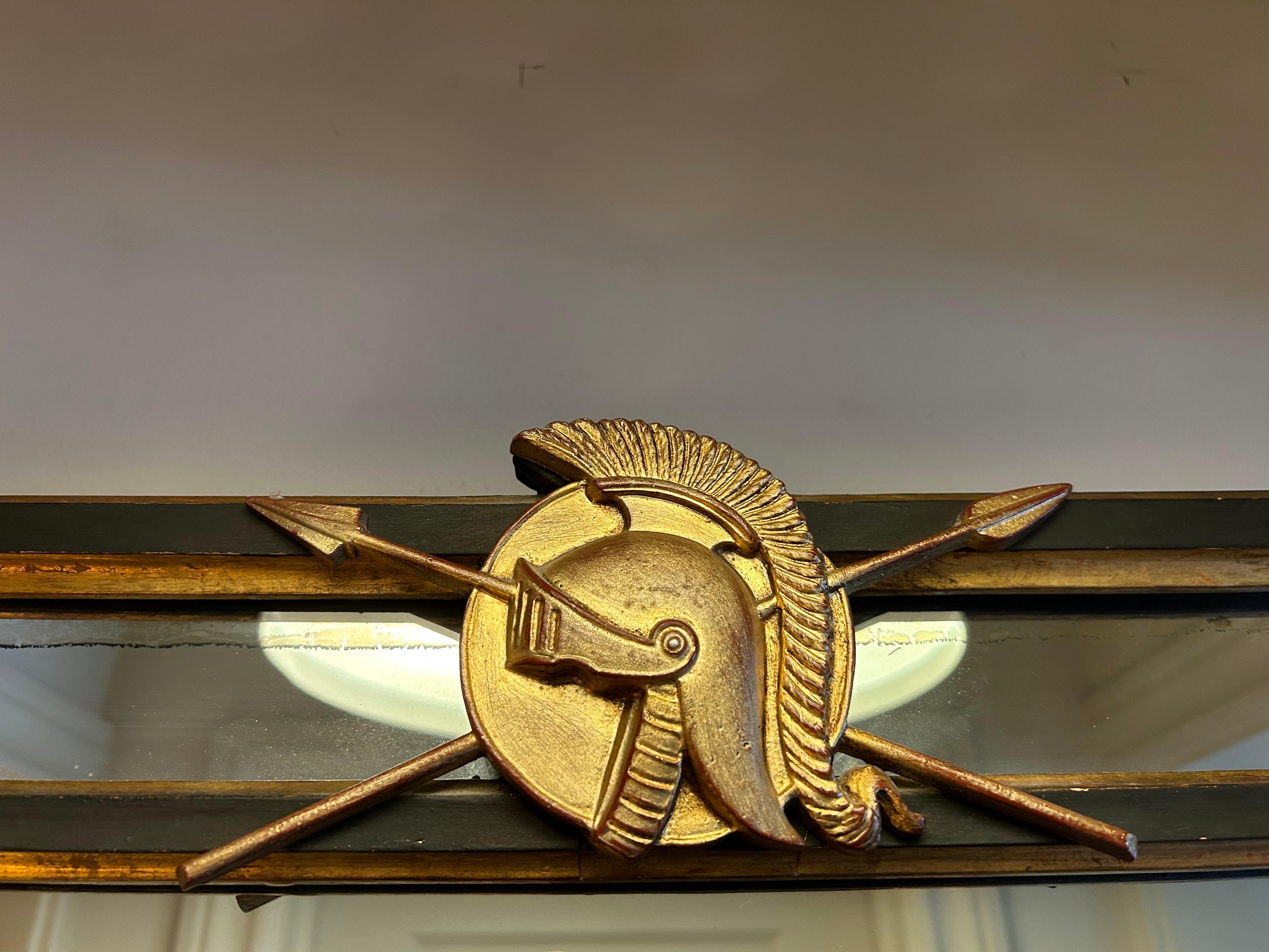 Italian Neoclassical Style Ebonized And Giltwood Mirror.
This stunning rectangular mid century Italian black and gold mirror features
applied gilt arrows, faces and lions head. This versatile Hollywood Regency mirror is perfect in an entrance hall,