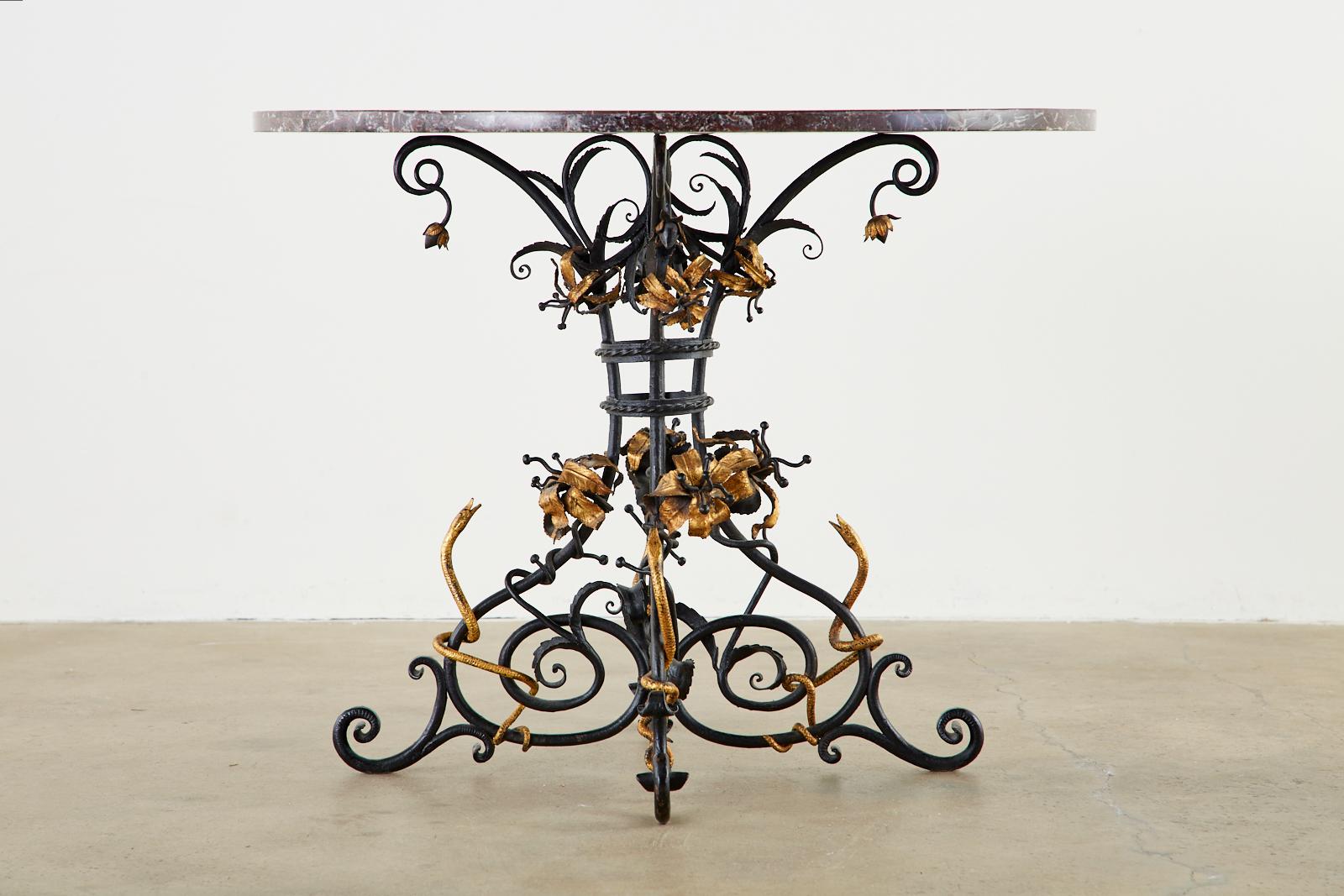 Dramatic Italian centre table featuring a Pietra Dura mosaic marble specimen round top. The 1 inch thick marble is inlaid with intricate neoclassical sunburst patterns centered with four snakes in an orb. Supported by an iron base with scroll legs