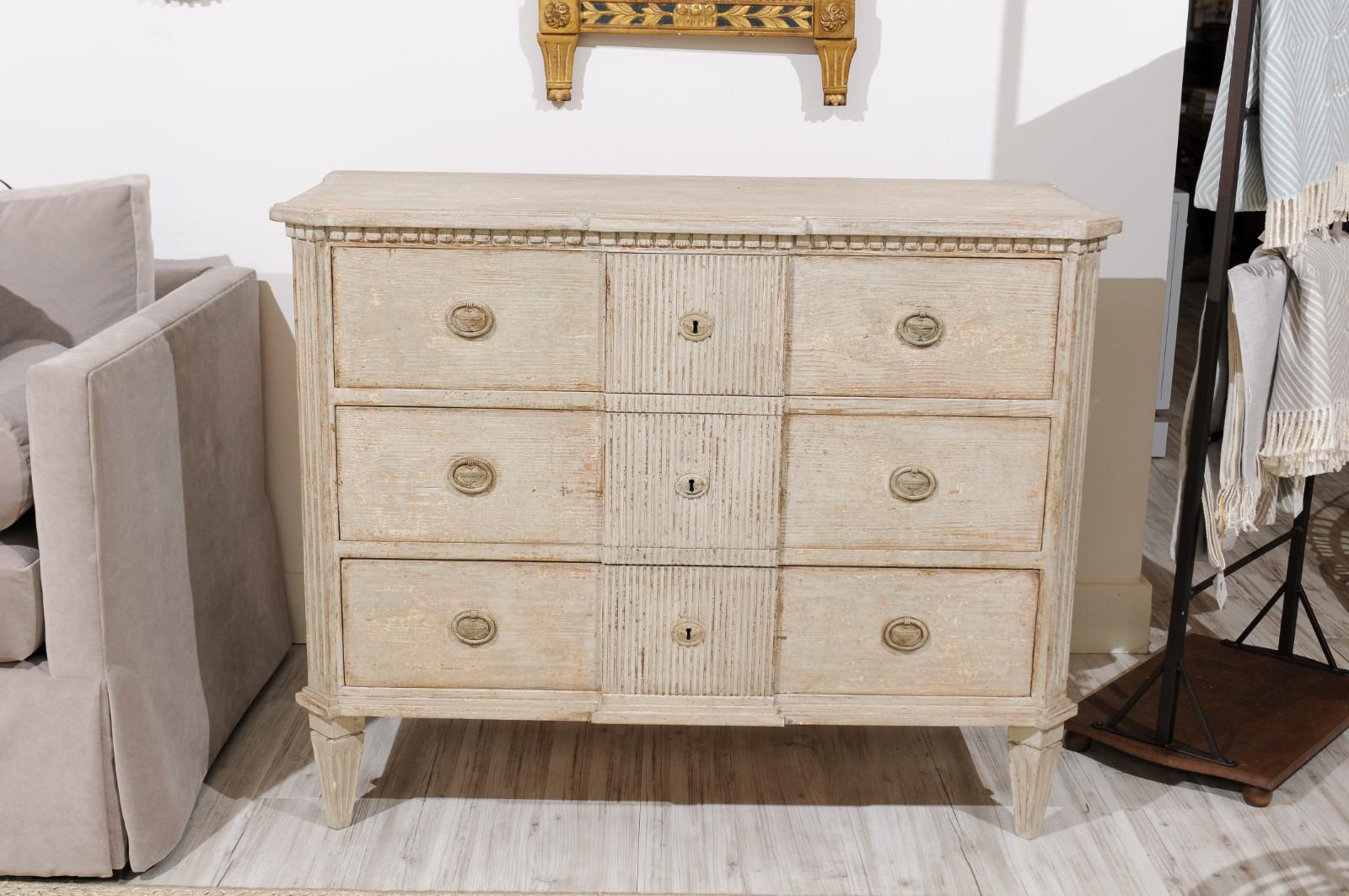 Italian neoclassical style grey painted pine three-drawer commode from the early 20th century, with dentil molding, canted fluted side posts and feet and reeded motifs. Newly constructed in Italy from old pine, this beautifully crafted neoclassical