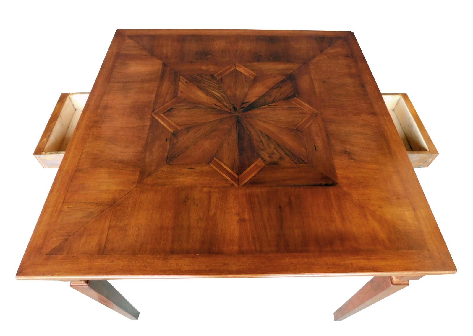 The square top centering a parquetry inlaid star above an apron fitted with 2 drawers; raised on square tapering supports with waisted neck.