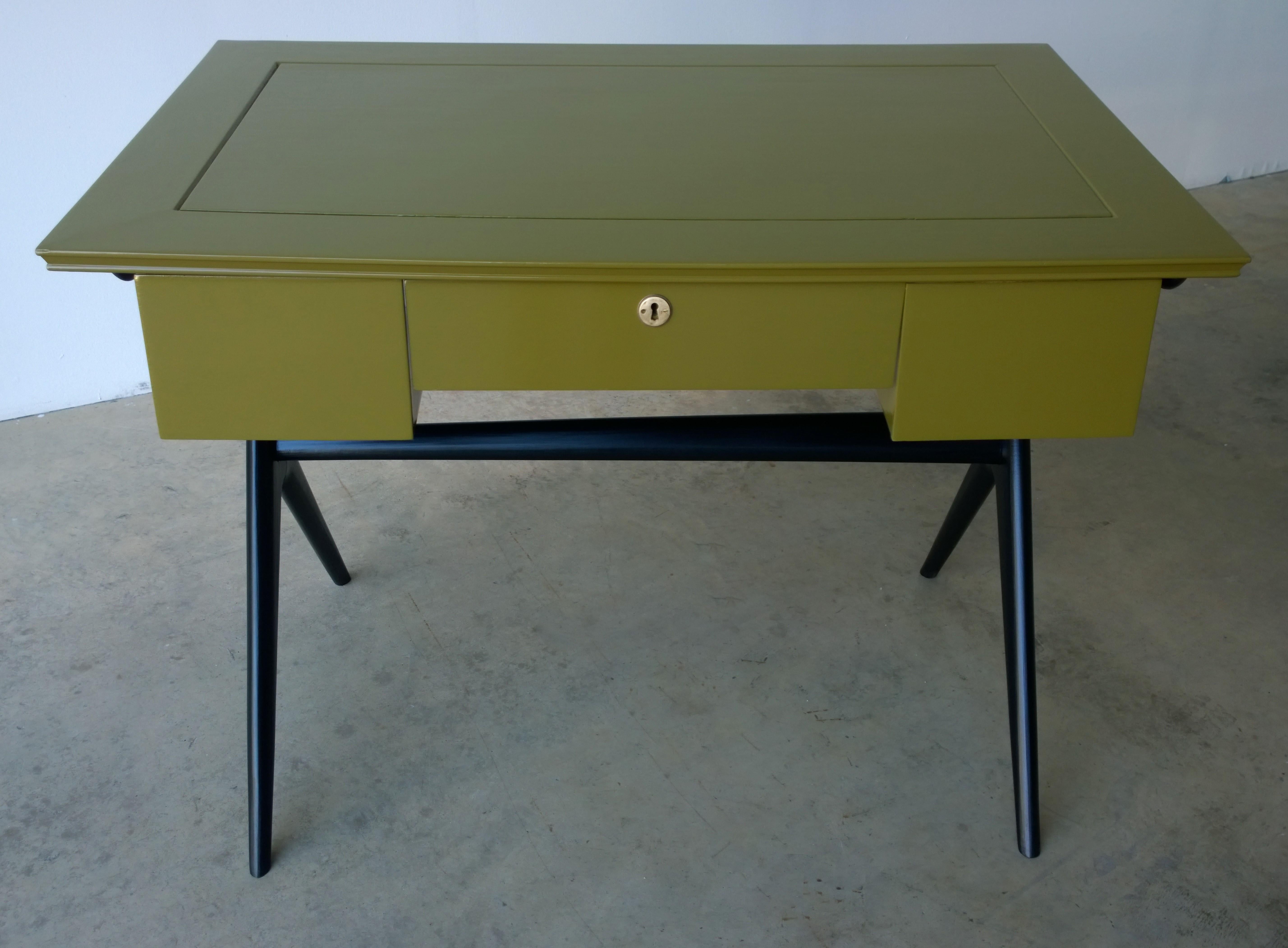 Offered are an Italian Mid-Century Modern one drawer desk / writing table newly lacquered in a bronze like green body with black legs. The one drawer has a brass lock. This very elegant desk / writing table was lacquered in a bronze green giving the