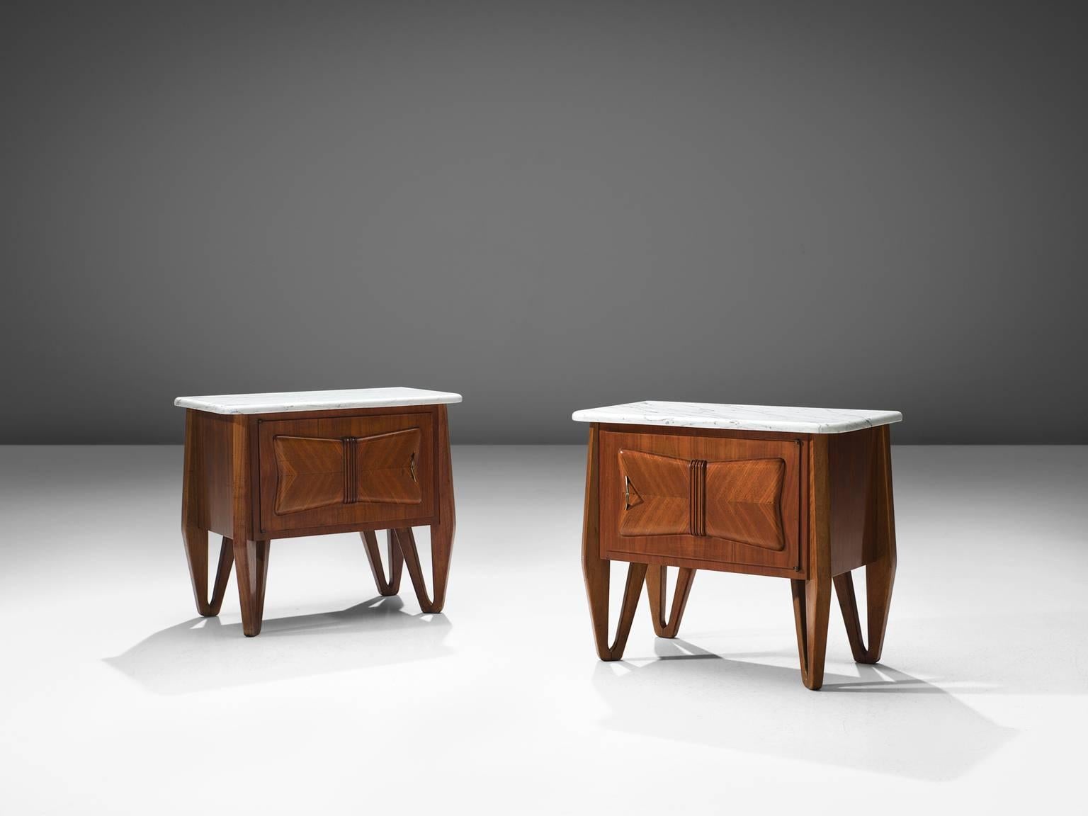 Set of two small cabinets, in wood, marble and brass, Italy, circa 1950.

These two Italian nightstands are executed in wood and have a clean white marble top with white veins. The stands are very sculptural and feature tripod legs. On the front