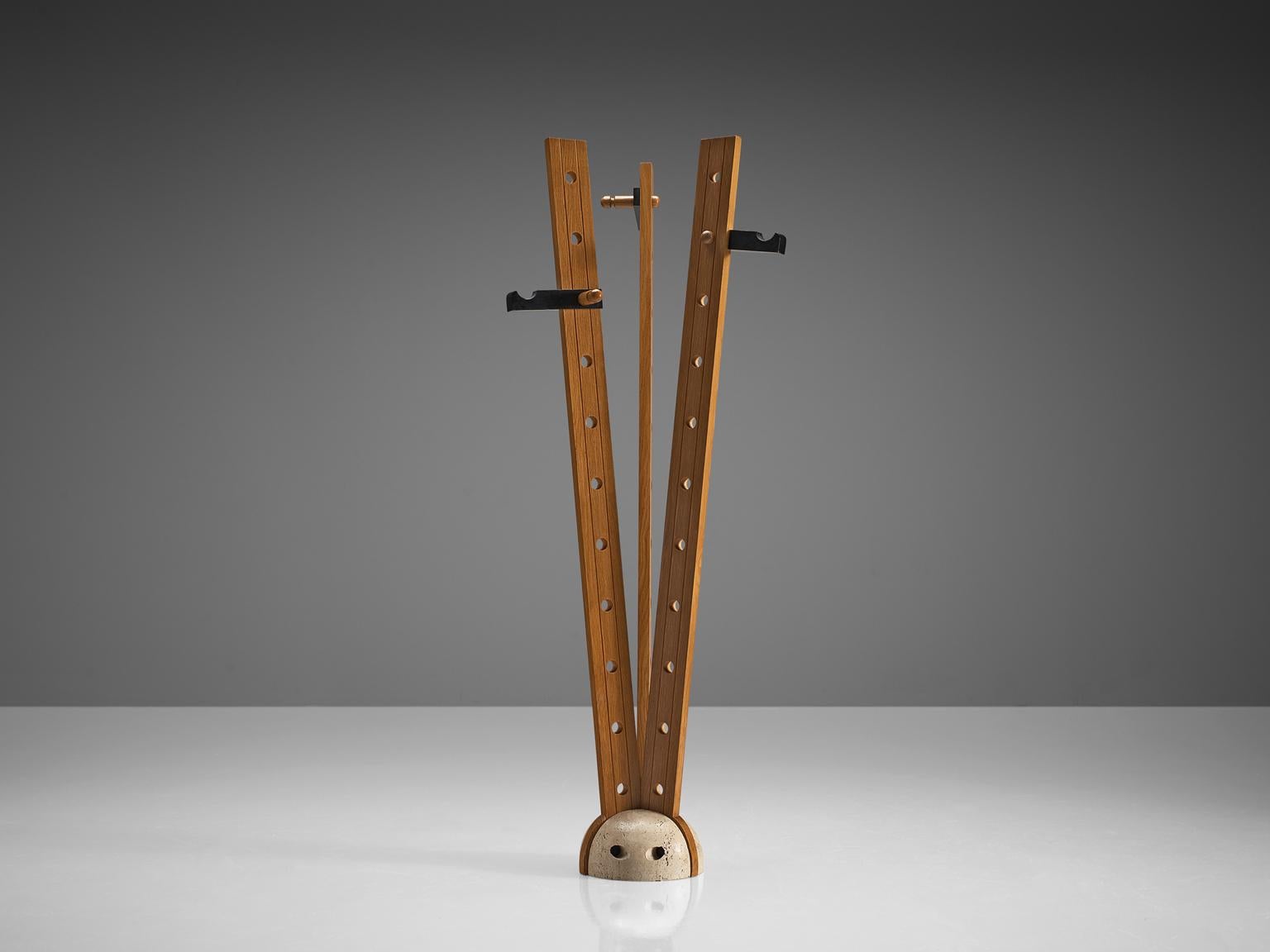 Coat rack, oak and travertine, Italy, 1970s.

This coat rack features a solid beige travertine base and three solid oak stems. The oak stems rise up from the base and each stem has eleven holes. The holes are both aesthetic and functional as the