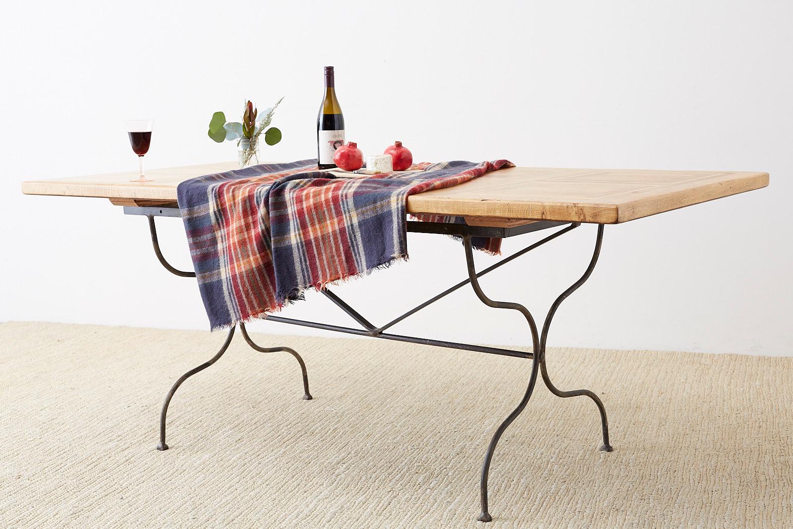 Rustic Italian farm table featuring an iron trestle style base. The thick oak top is constructed with geometrical inlay with square patterns on top. Excellent joinery and craftsmanship that showcases the rich oak grain patterns. The iron base has