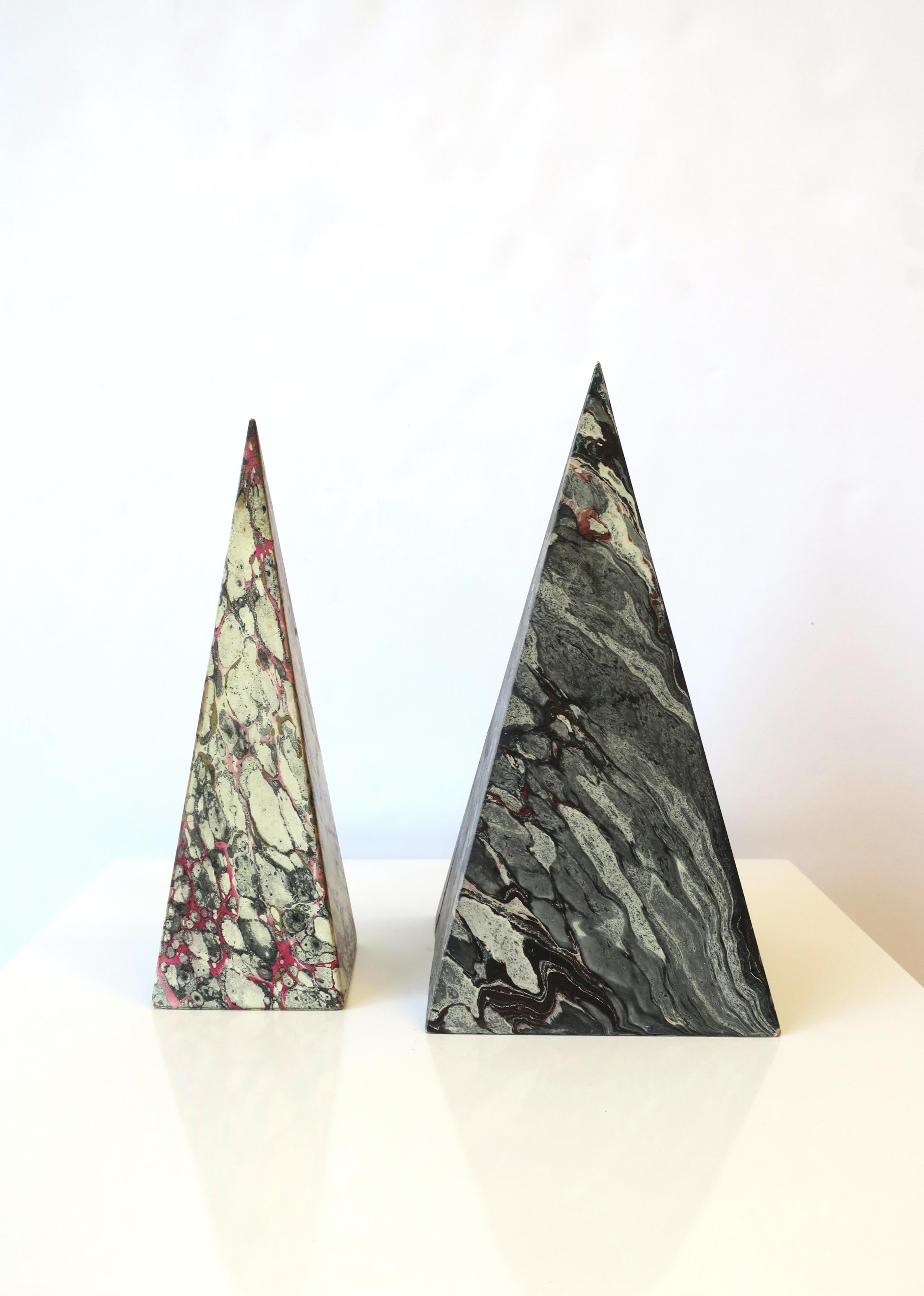 A beautiful set of two (2) pyramid Obelisks, in the Modern style, circa mid-20th century, Italy. Pyramids are wood, wrapped in hand designed Italian paper; One is a combination of white, gray, black and pink, and the other is shades of grey, black,