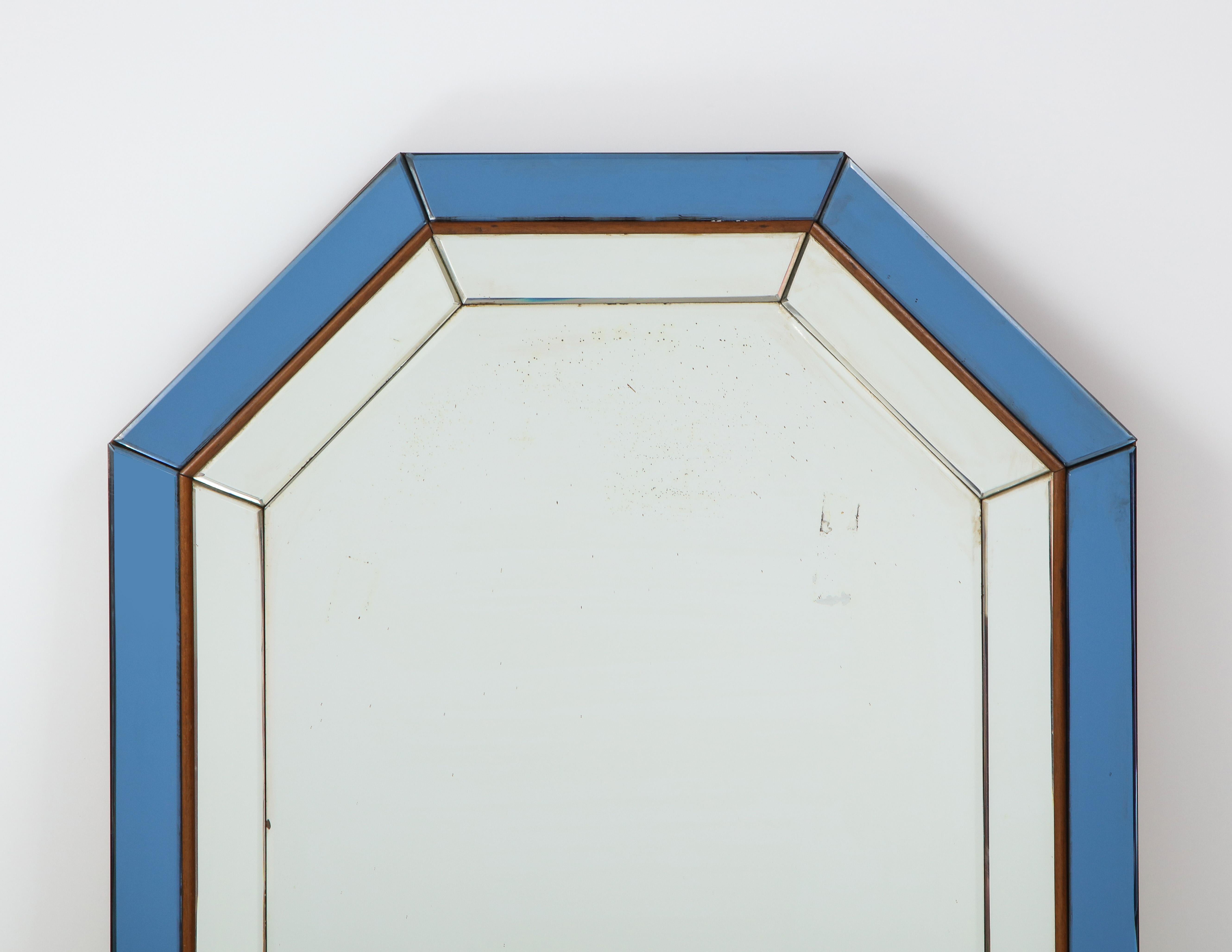 An Italian octagonal glass mirror with double molded design, the outer molding in a beautiful blue glass with wood surround which separates the interior clear glass segments; the whole mirror supported with a molded wood outer edge and