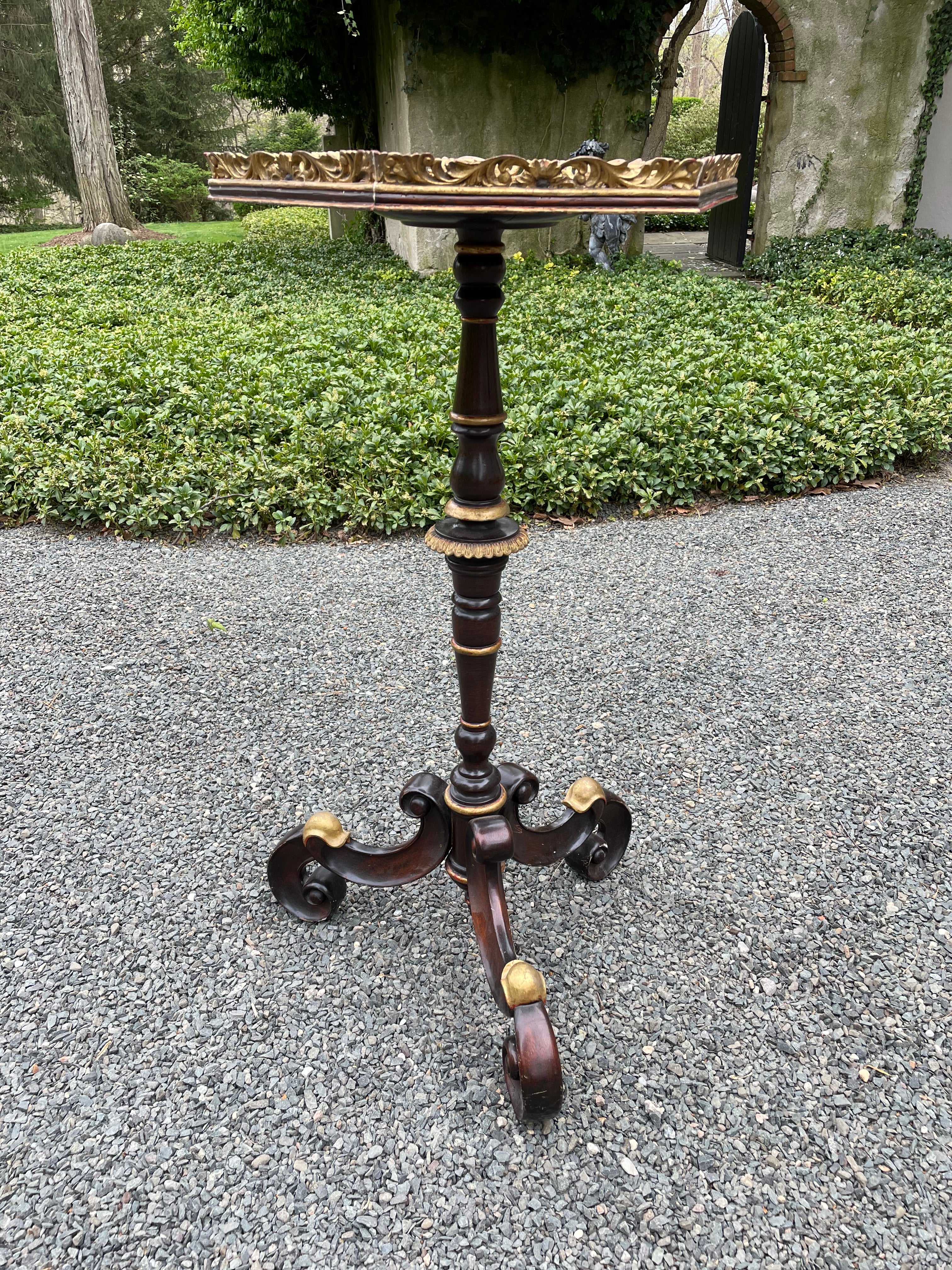 Elegant Italian side table or fern stand in mahogany with elaborate scrolled design base. Portions of the base and the octagonal gallery on top are gilded.