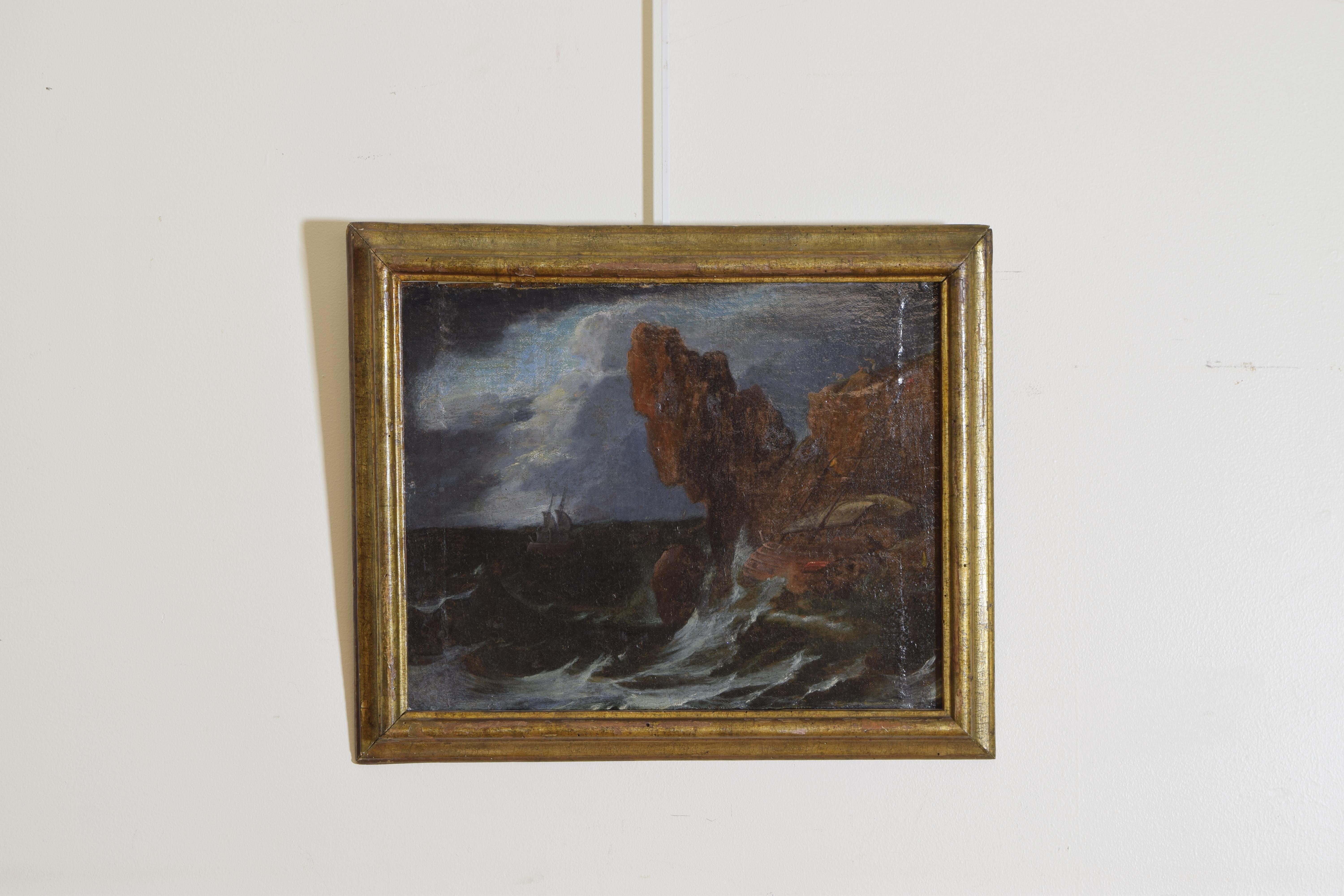 Men desperately try from above to save the ruined vessel as the waves pound it into the cliffs, another galeone passes helplessly in the background with still another in the center background, in a period early 18th century giltwood frame.