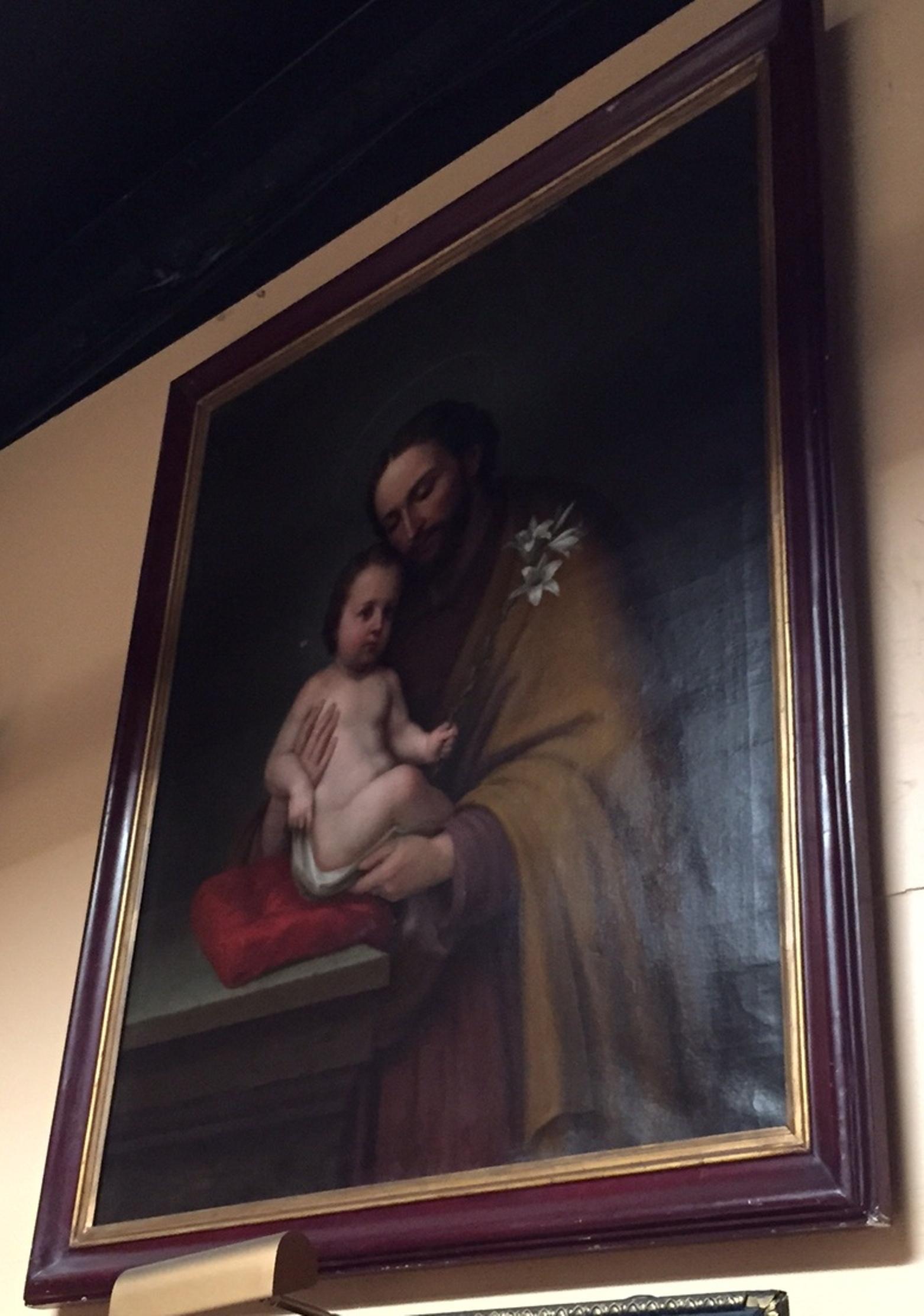 Exquisite late 19th century Italian oil on canvas painting. 
The framed painting depicts a finely hand painted oil on canvas of St. Joseph holding Baby Jesus while seated on a red cushion. Baby Jesus is wielding a bough of flowers in his hand.