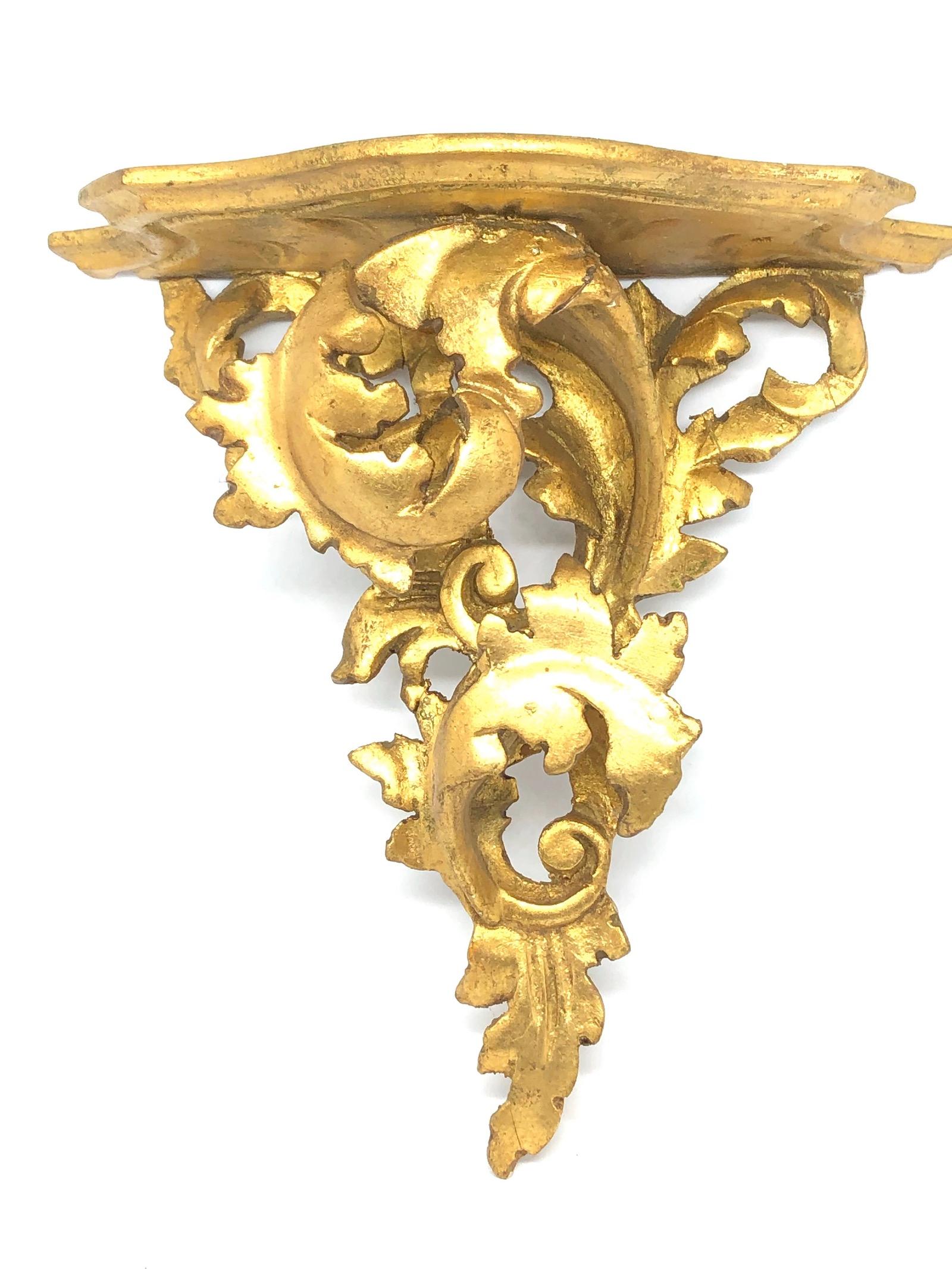 Offered is an absolutely stunning, 1950s Italian giltwood wall shelf or wall console. Minor patina and paint lost gives this piece a classy statement. Made of hand carved wood and gold plated. A nice shelf to present a statuette or a beautiful