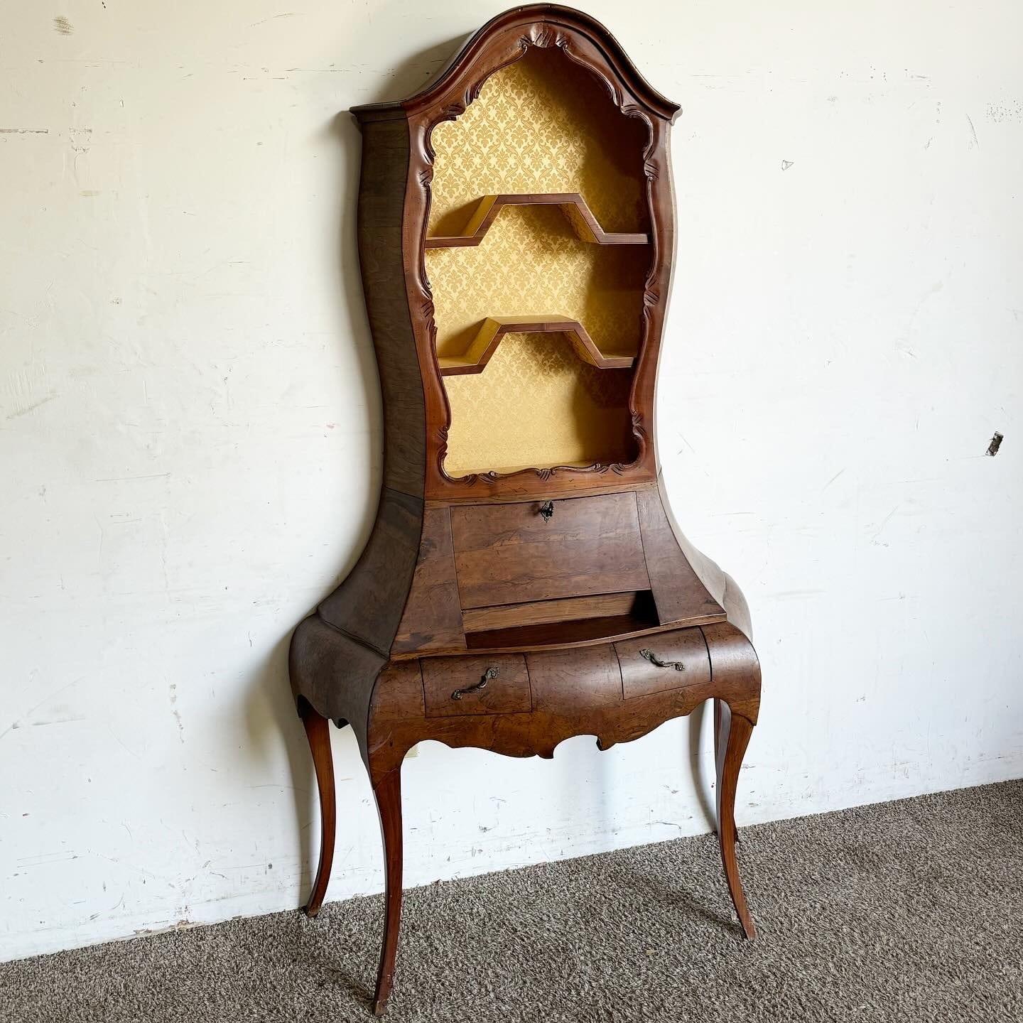 Elevate your home decor with the exquisite Italian Olive Burl Wood Secretary Desk. Featuring elegant cabriole legs and a distinct bombé shape, this vintage piece combines functionality with timeless beauty. The intricate bookshelf and spacious