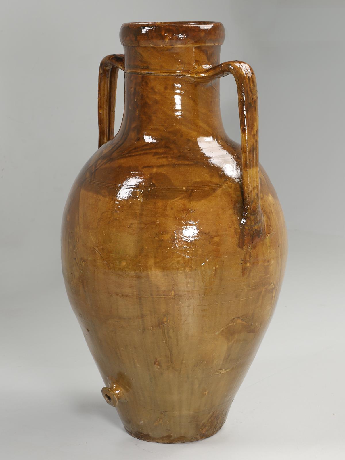 Italian glazed olive oil jar signed and dated 1935. More correctly called amphora jars, which originated from the Neolithic Period between 9000BC to 3500BC. Amphorae were used primarily to transport olive oil and wine. Interior designers and most