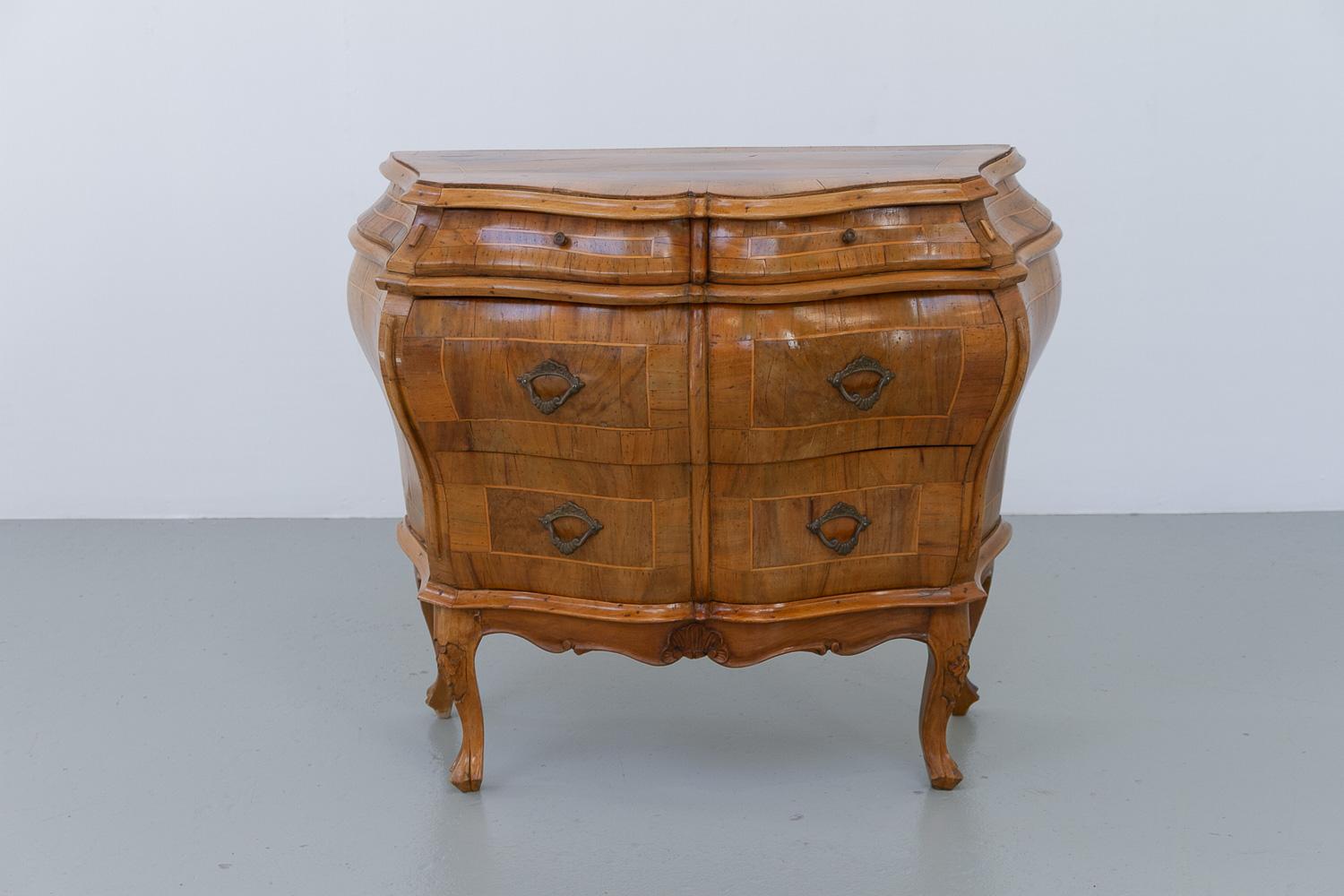 Italian Olive Wood Bombe Chest of Drawers Rococo Style, 1950s.

Delightful small Italian six drawer commode in rich olive wood inlay. Cast bronze pulls and cabriole legs with carved details.

Beautiful bombe shaped body. Made in Italy circa 1950.
