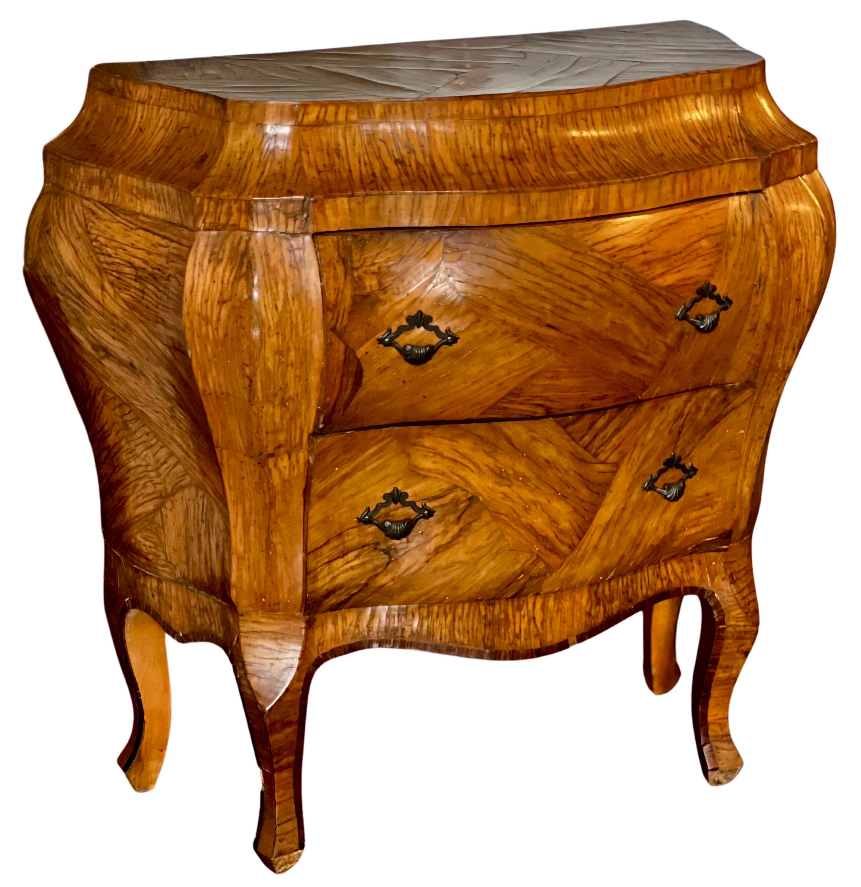 Italian Rococo style olive wood bombe chest, c. 1920.

Sophisticated petite commode crafted of olive wood with a unique parquetry design. It is a great size allowing it to be extremely versatile. Two deep drawers with original handles provide plenty