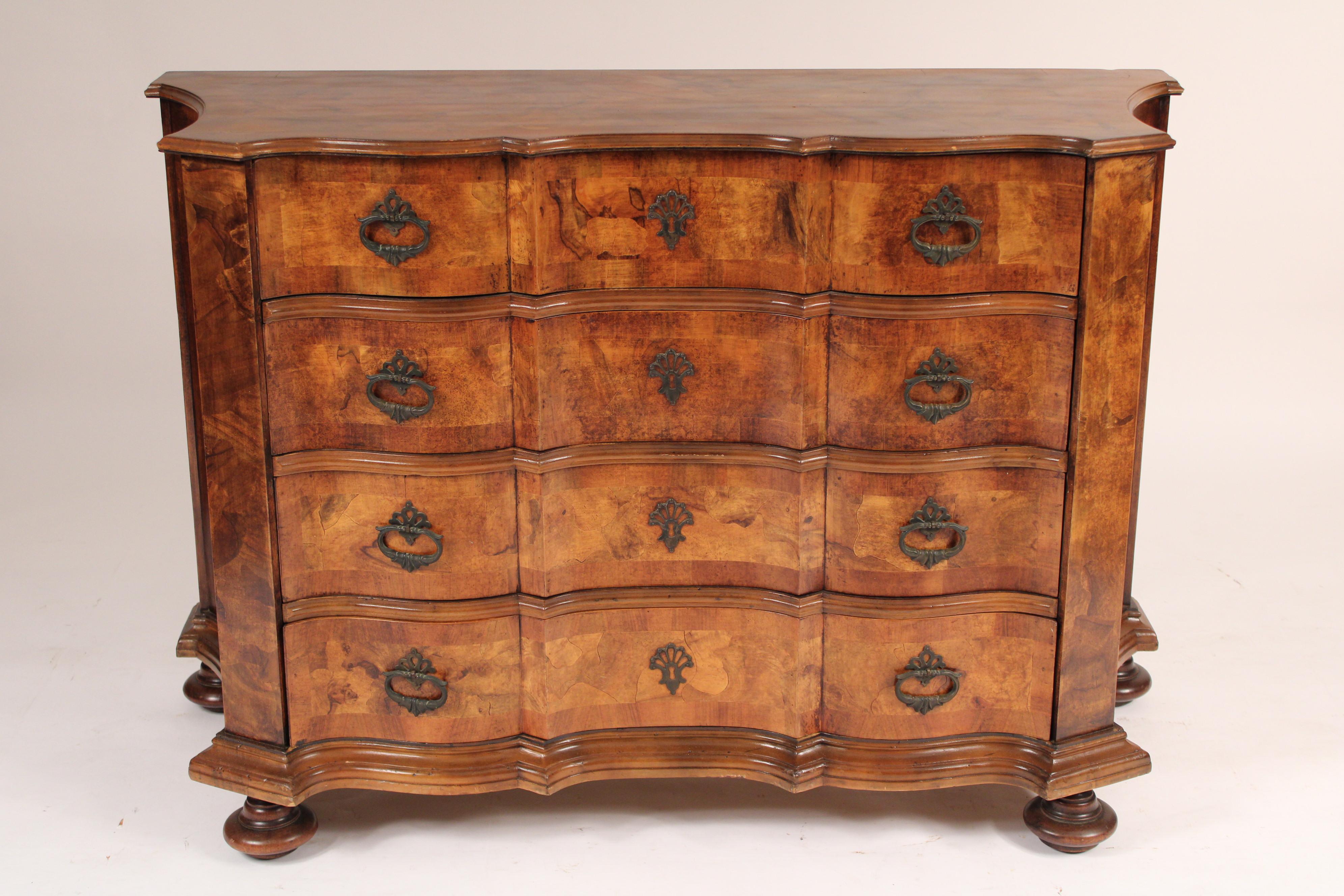 Italian baroque style olive wood chest of drawers, circa mid 20th century. With a double serpentine shaped overhanging top, 4 nicely figured olive wood drawers with bronze hardware, concave shaped sides,  resting on bun feet. 