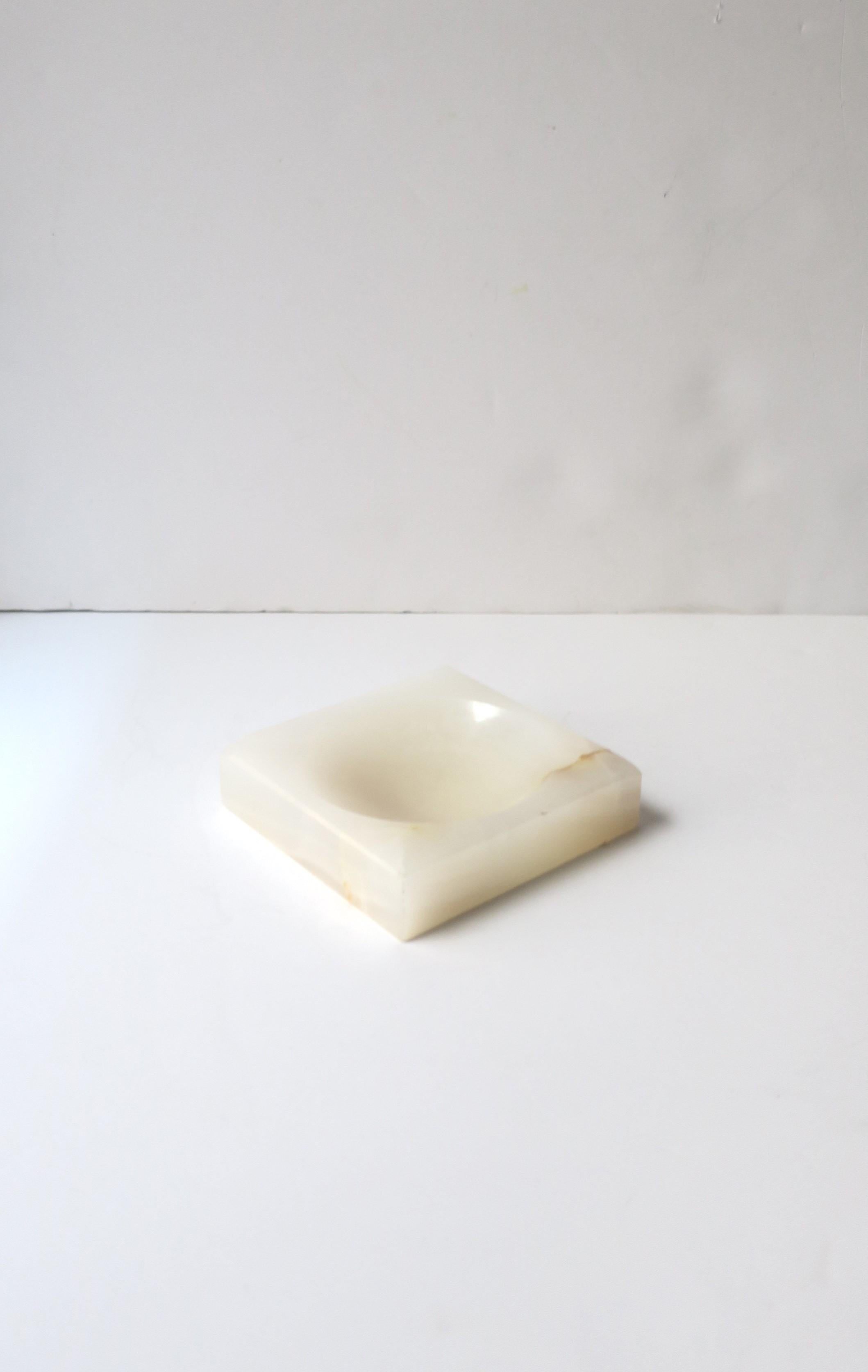 An Italian white/off white onyx marble ashtray (or jewelry dish), Mid-Century Modern period, circa mid-20th century, Italy. Use as ashtray, with two indents for cig., or use to hold jewelry (as demonstrated) or other small items on a desk, vanity,