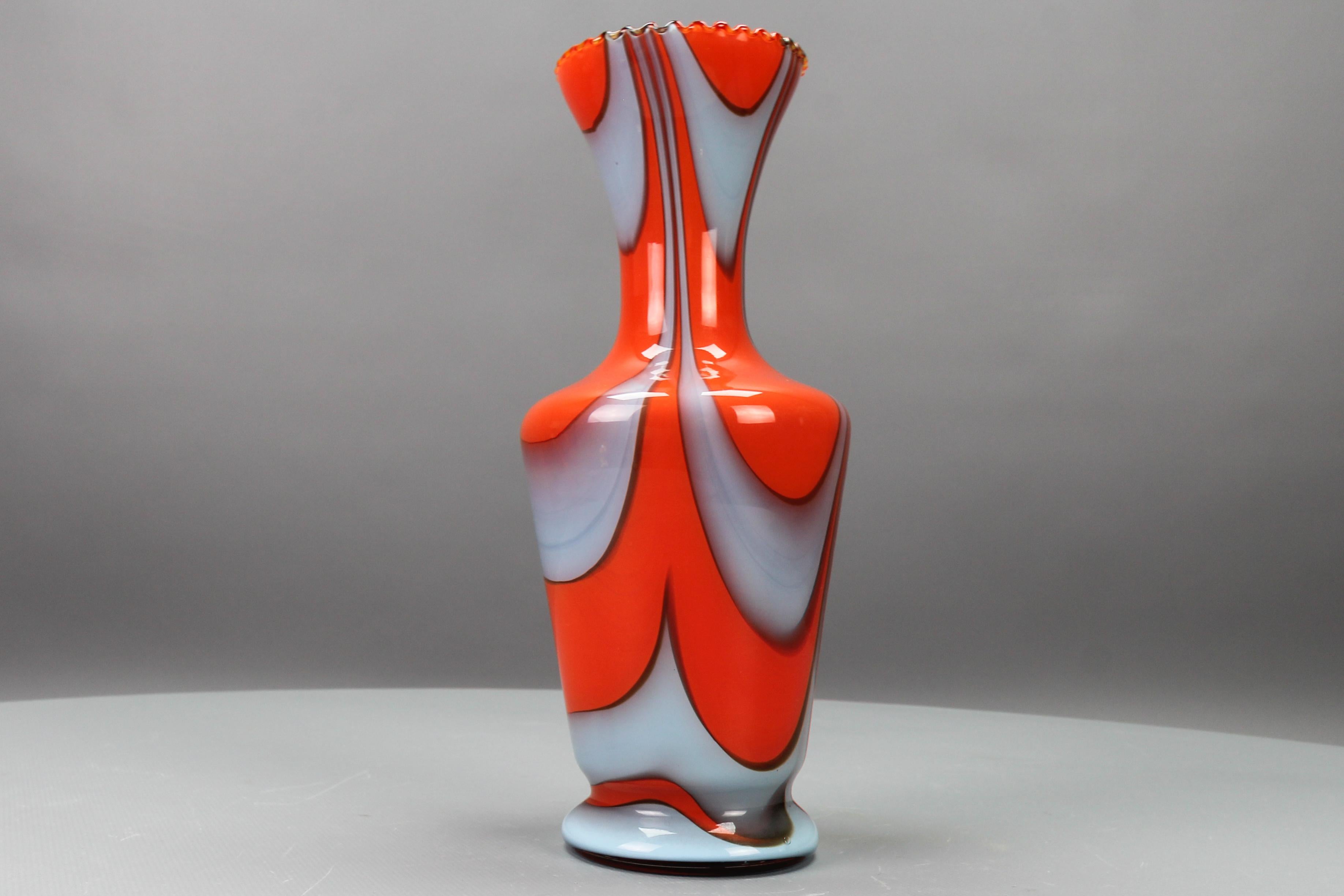 Italian Opaline Florence glass vase in red and grey attributed to Vetreria Barbieri, circa the 1970s.
This beautiful Mid-Century Modern period hand-blown vase features a red body with light grey swirls that give it an exquisite appearance. The rim