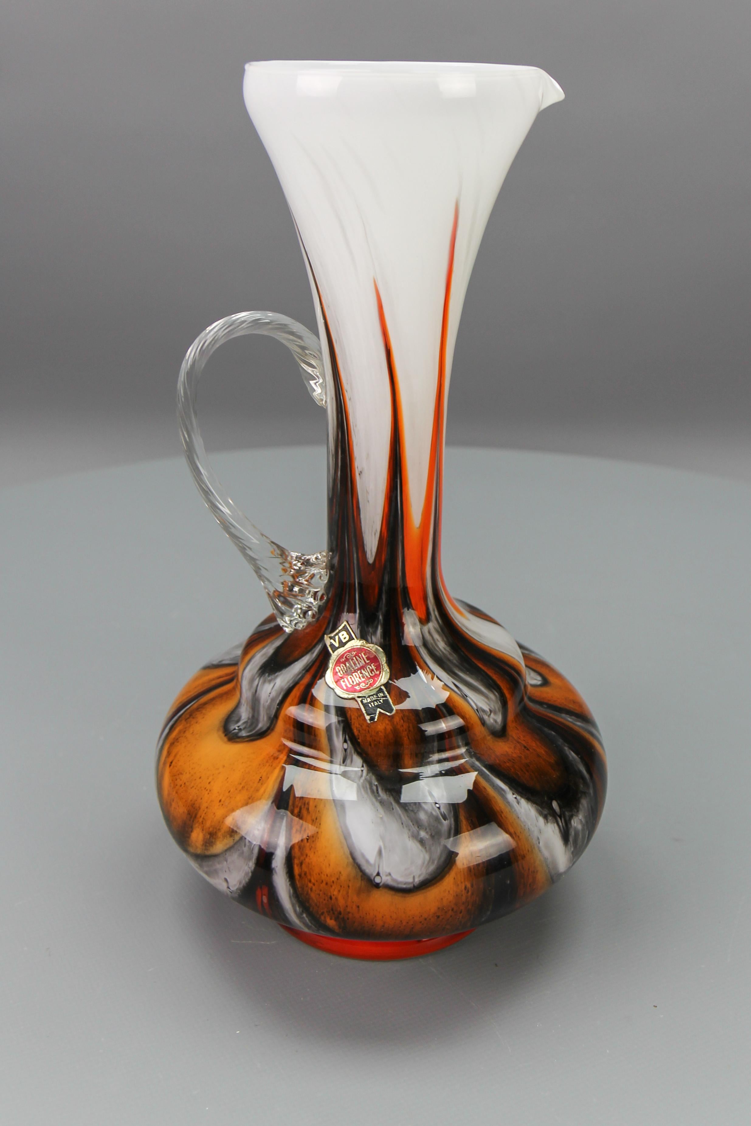 Italian Opaline Florence glass vase in white, brown, orange, and red by Vetreria Barbieri, circa the 1970s.
A beautiful polychrome brown, orange, red, white, and grey marbled vase, pitcher, or jug with a clear glass handle, made in the region of