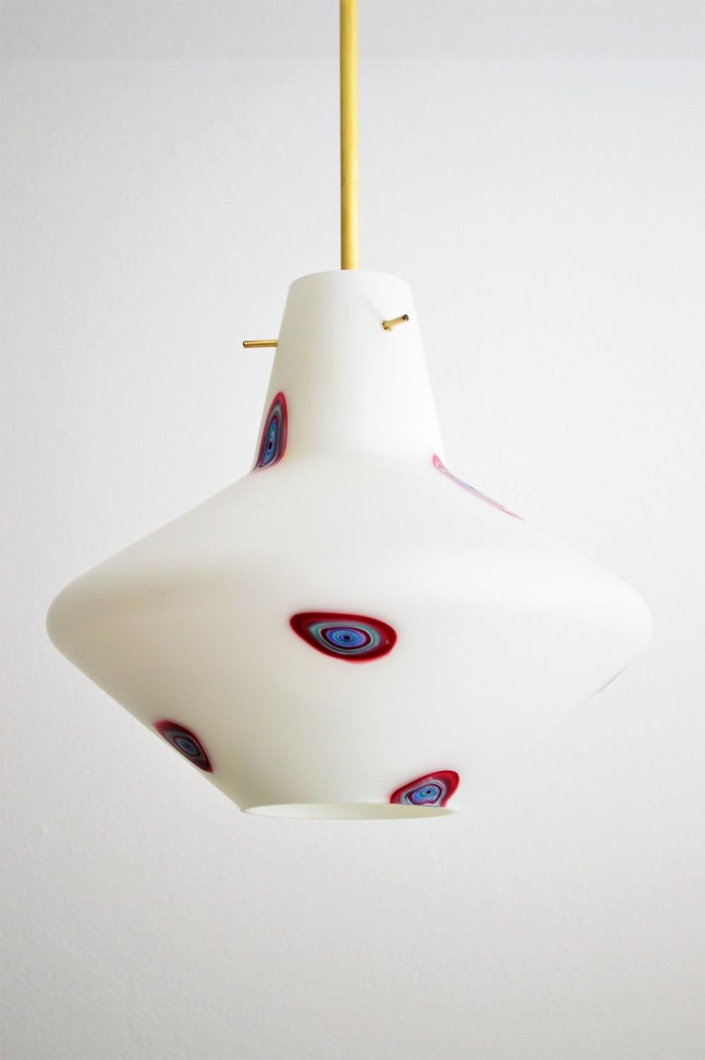Beautiful glass pendant lamp in onion form and opaline white color with colorful spots within the glass, typical of the Italian modernist era.
The pendant light have been completely restored and equipped with new brass hanging device and bulb