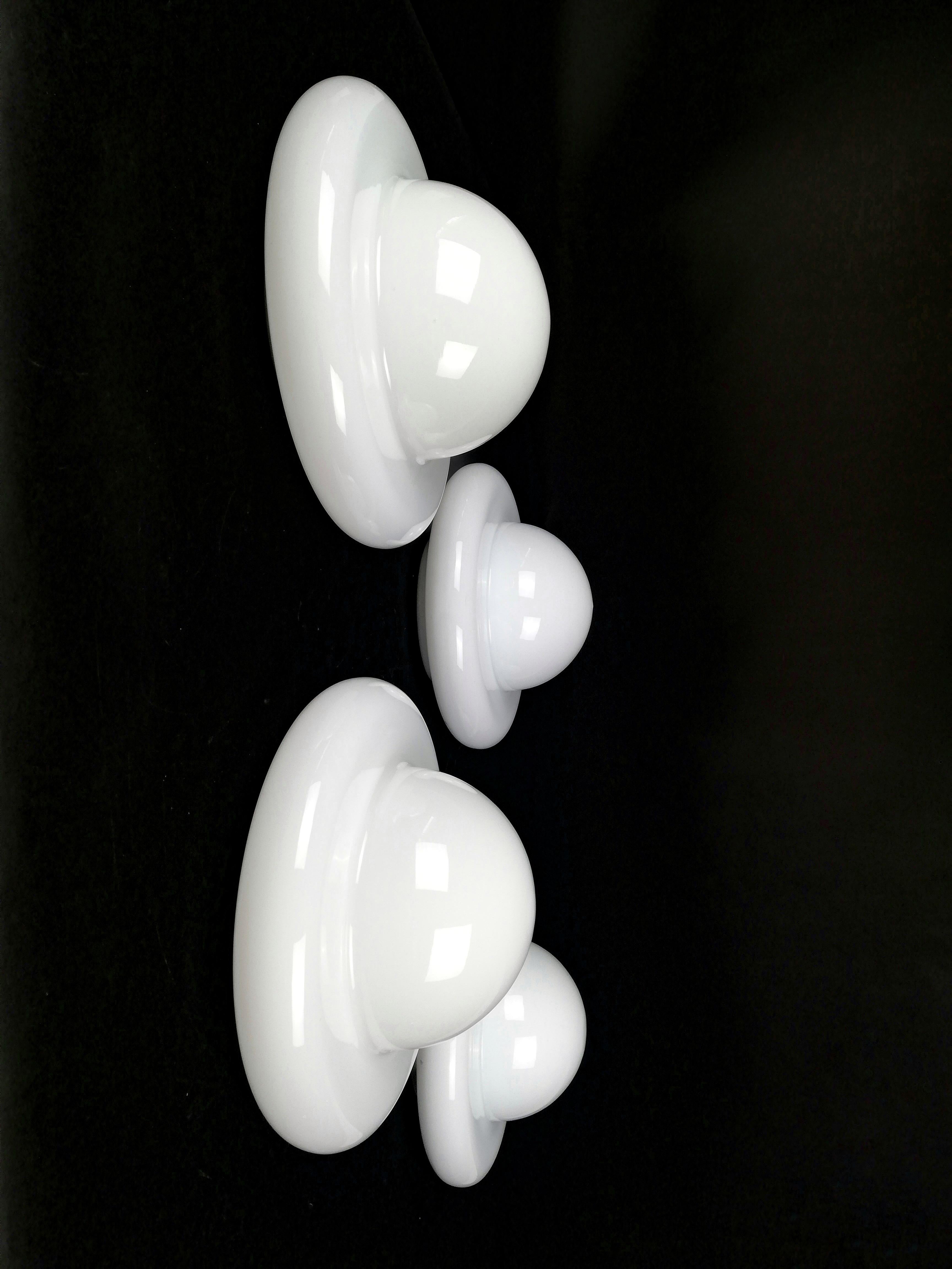 An interesting number of Italian wall lights made in Italy and datable around the 70s.
These four Space Age sconces were made in opaline glass with a soft and playful shape, to be used like appliques but also like a ceiling light.
Manifesto of the