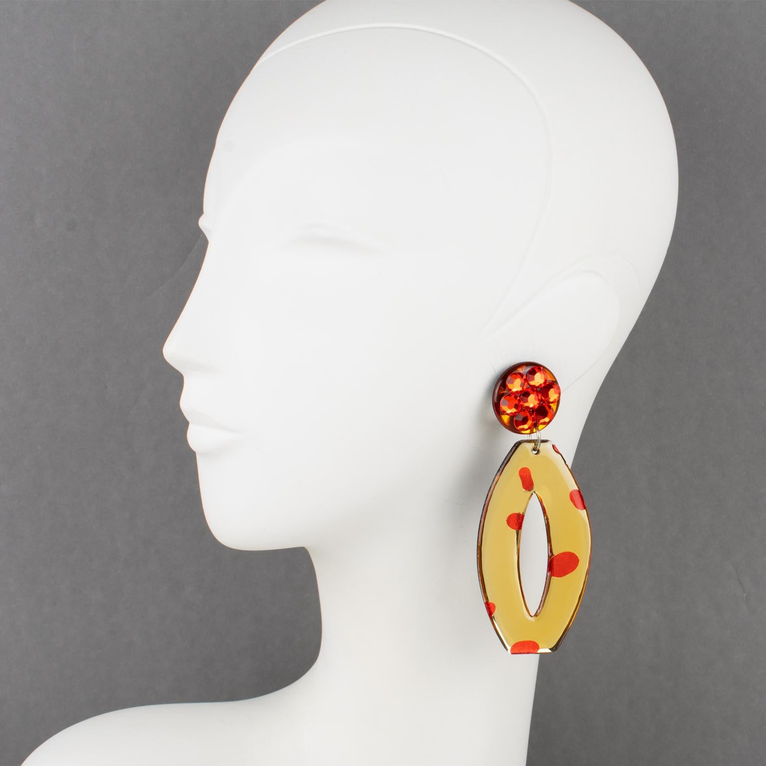 These fabulous Italian designer studio Lucite or resin dangling clip-on earrings boast a chandelier shape with a geometric elongated donut design in beige champagne and neon orange colors with a mirror texture effect. The clip fittings are all paved