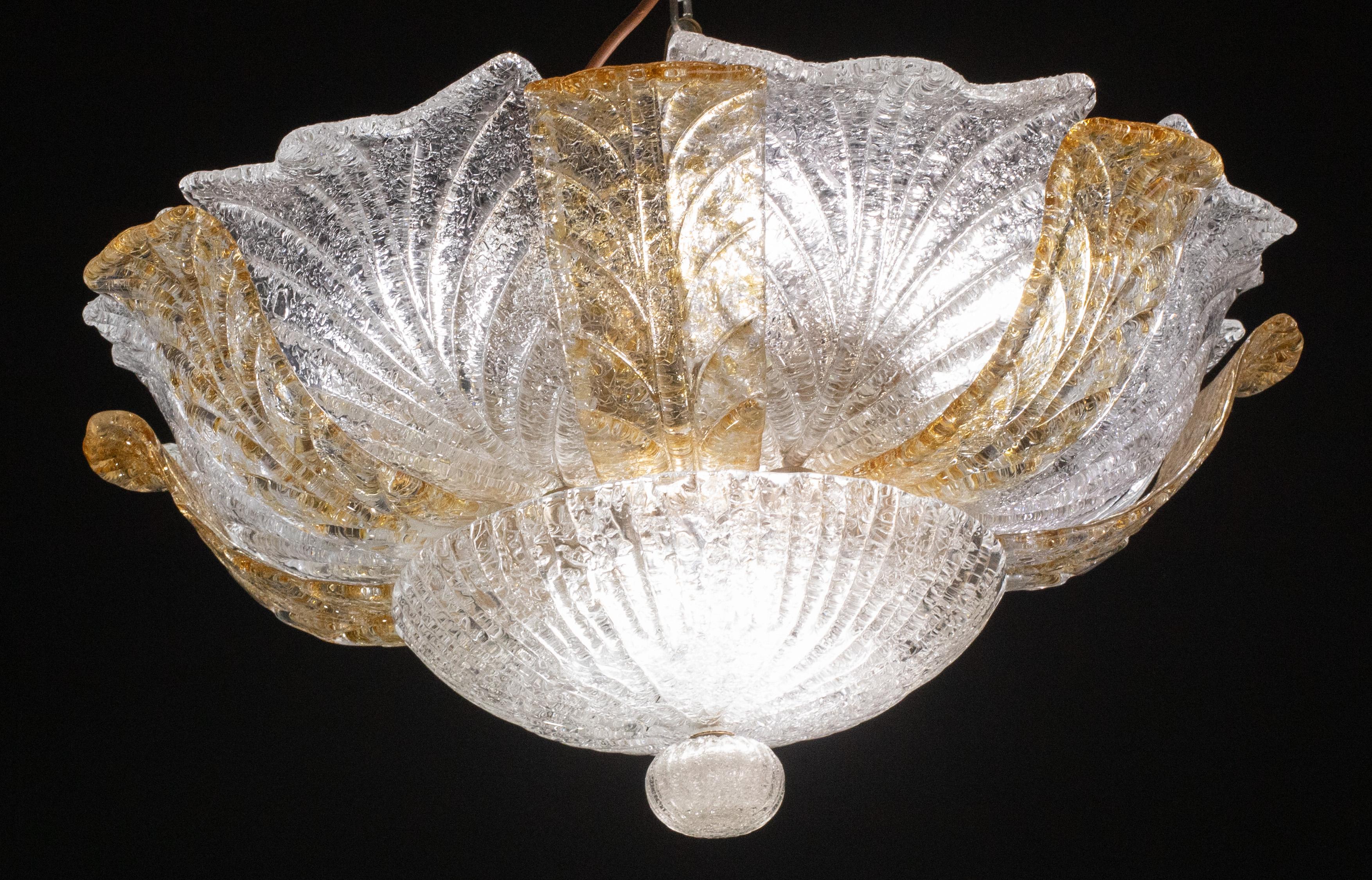 Gorgeous orange and transparent Murano ceiling light.
The ceiling light consists of a round of alternating atancioni\yellow and transparent glass leaves, the central plate.
The ceiling light mounts 9 lamp holders with E14 socket, possible to rewire