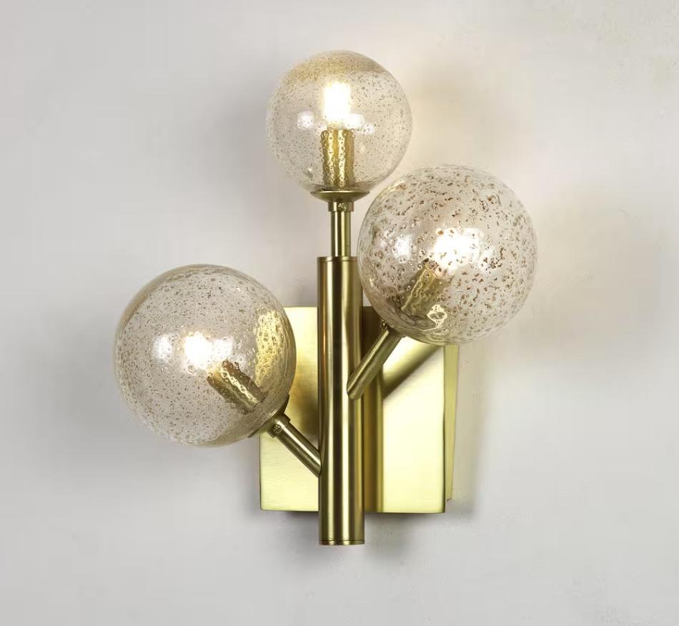 Elegant minimalistic organic sconce resembling a Craspedia bunch of flowers. Both delicate and modern, perfect for home and office, hallways, powder rooms and bedrooms, to illuminate any space. Mounted on a square base in brass finish, with a linear