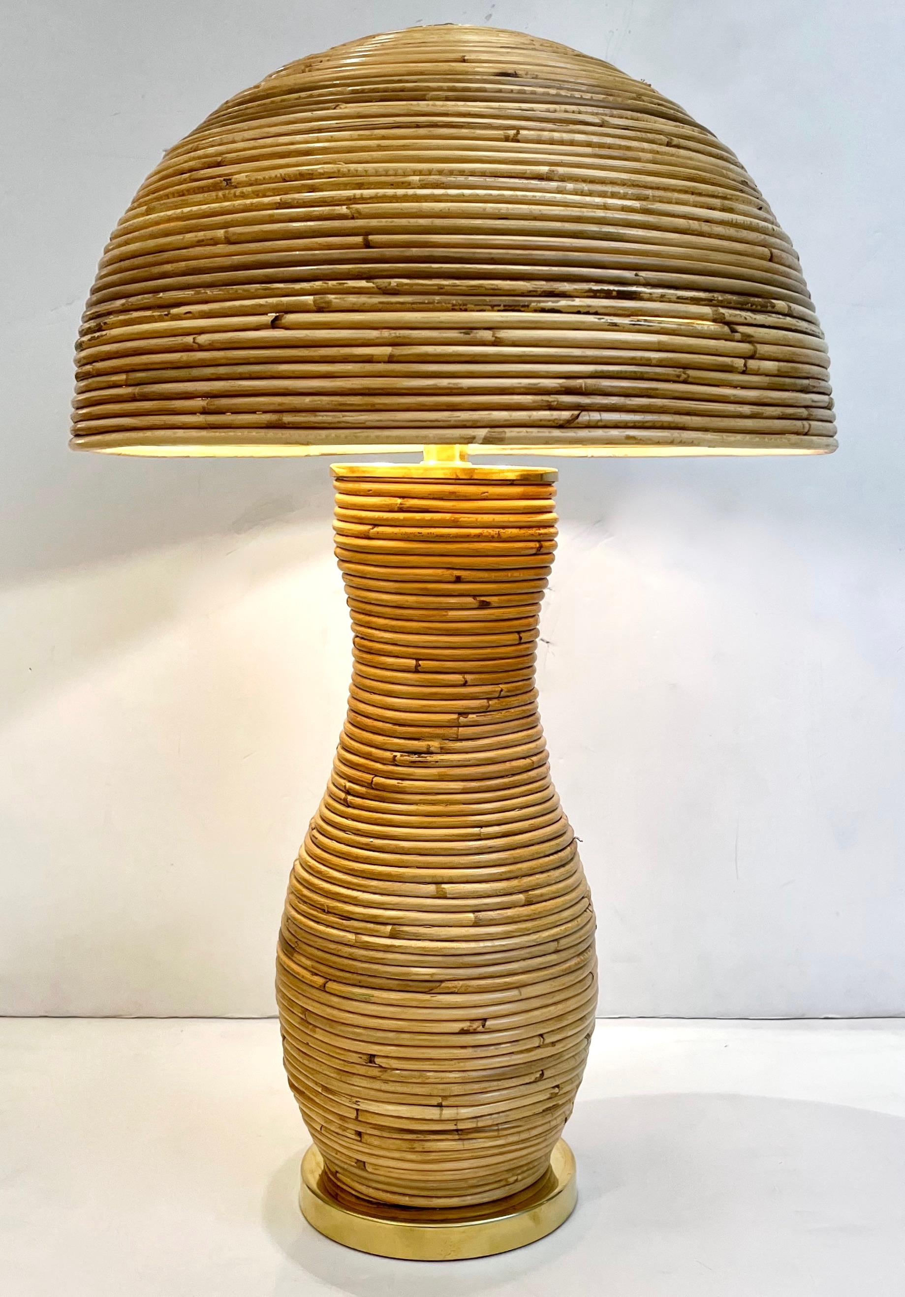 Une création contemporaine organique, entièrement réalisée à la main en Italie, une lampe à poser en bambou champignon, le corps sensuel et courbé entièrement décoré en rotin sur une base ronde en laiton et équipé d'un élégant abat-jour en demi-lune