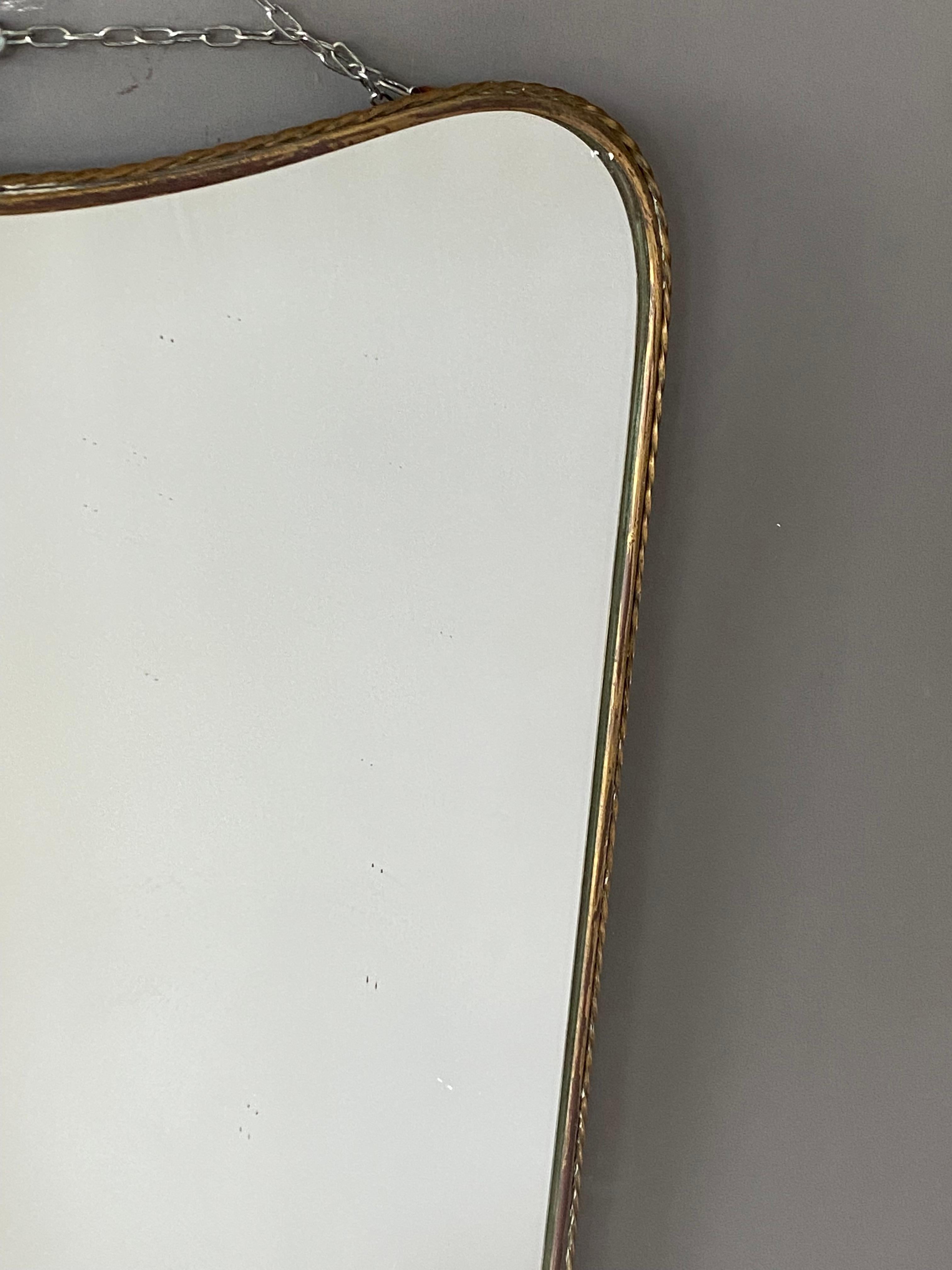 An organic wall mirror, produced in Italy, 1940s. Organically cut mirror glass is framed in brass. Features fine ornamentation.

Other designers of the period include Gio Ponti, Fontana Arte, Max Ingrand, Franco Albini, and Josef Frank.