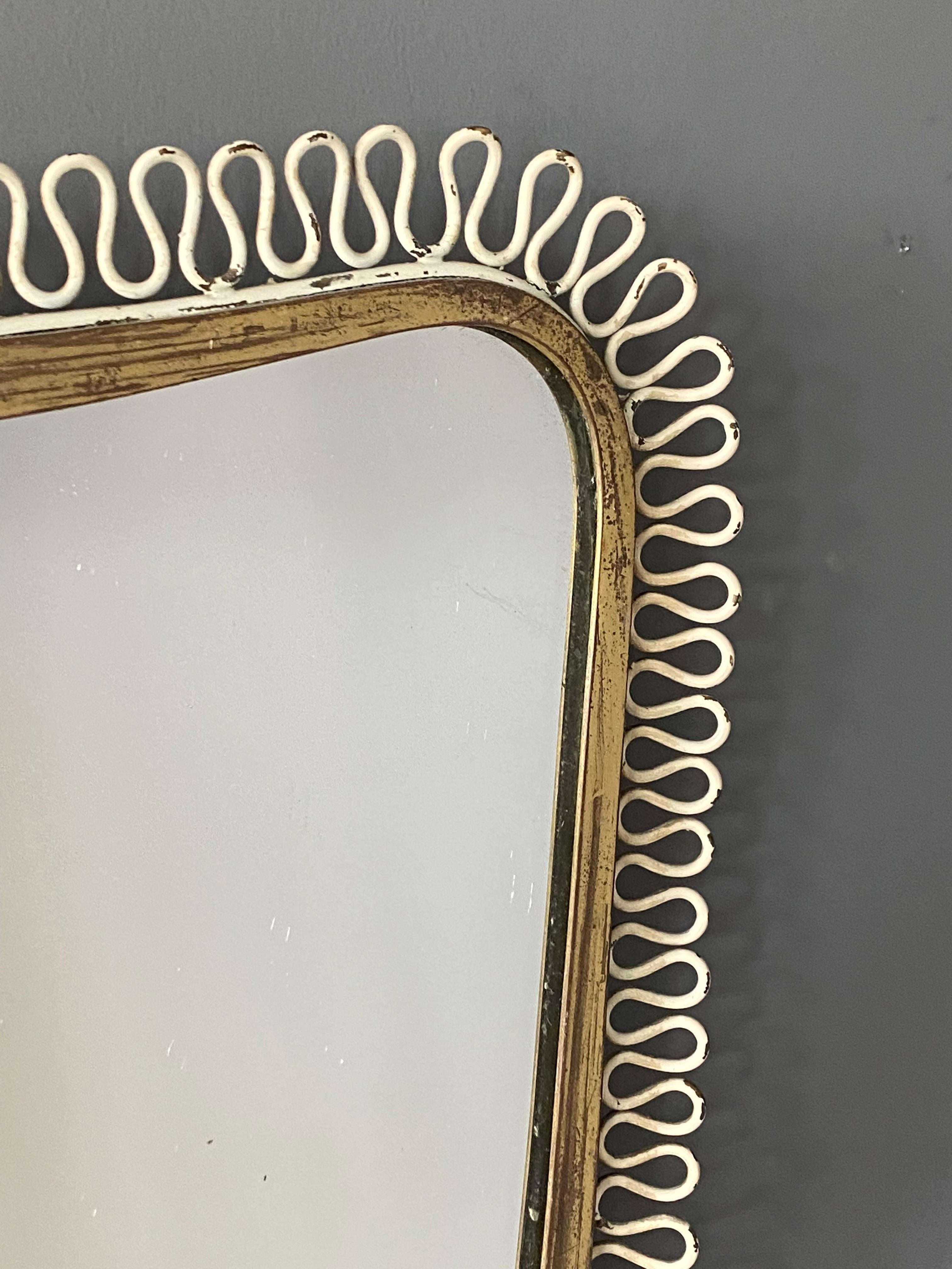 An organic wall mirror, produced in Italy, 1940s. Organically cut mirror glass is framed in brass. Features fine ornamentation in original white paint.

Other designers of the period include Gio Ponti, Fontana Arte, Max Ingrand, Franco Albini, and