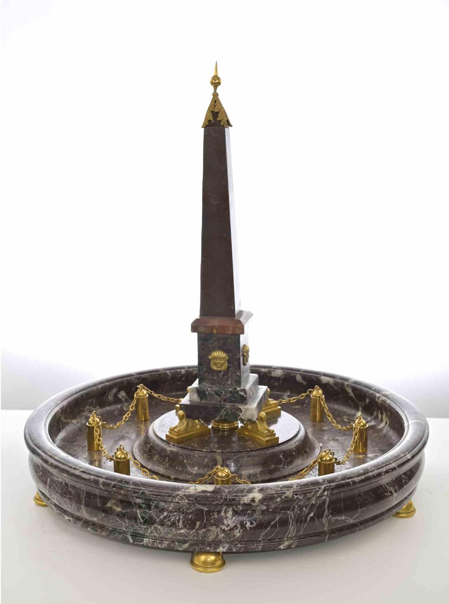 Obelisco italiano con montatura ad ormolu in vari marmi, tra cui porfido e rosso levanto, con decorazioni in bronzo dorato.

Italia, fine del XIX secolo.

Ottime condizioni.