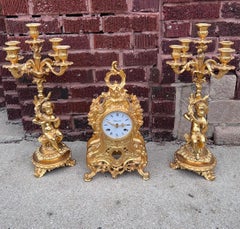 Italienische verschnörkelte Kaminuhr mit zwei figuralen Cherub-Kandelabern – Garnitur-Set