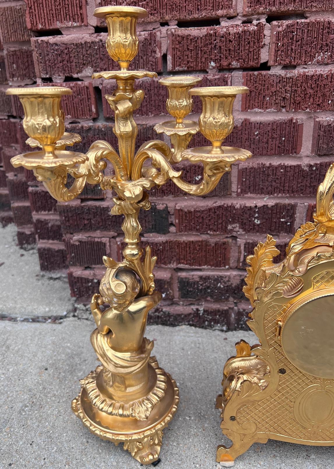 Brass Italian Ornate Mantel Clock with Two Figural Cherub Candelabras - Garniture Set For Sale