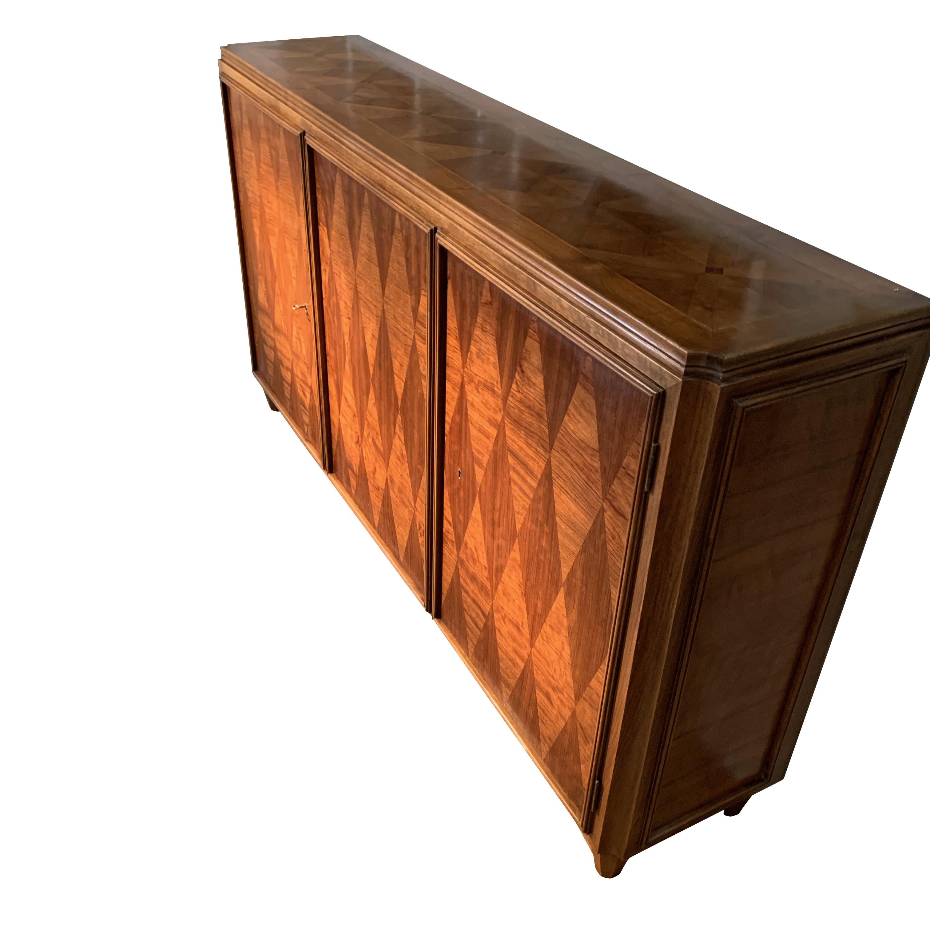 1930s Italian walnut wood credenza in the style of designer Osvaldo Borsani.
Decorative parquet designed front with inlaid pattern top.
The credenza has three doors and inner shelves.

 