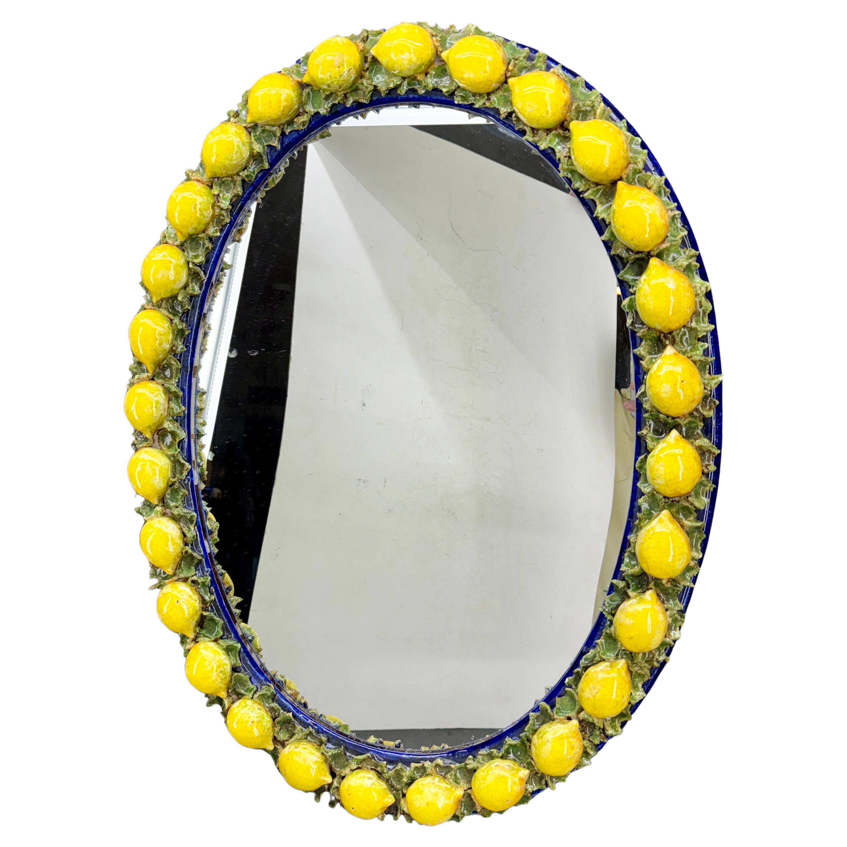 Charming bright and cherry Italian majolica oval mirror decorated with of frame of ceramic glazed lemons. Please note the amazing Florentine wall paper back of the mirror.
This substantial mirror certainly would make a statement in a foyer, dining